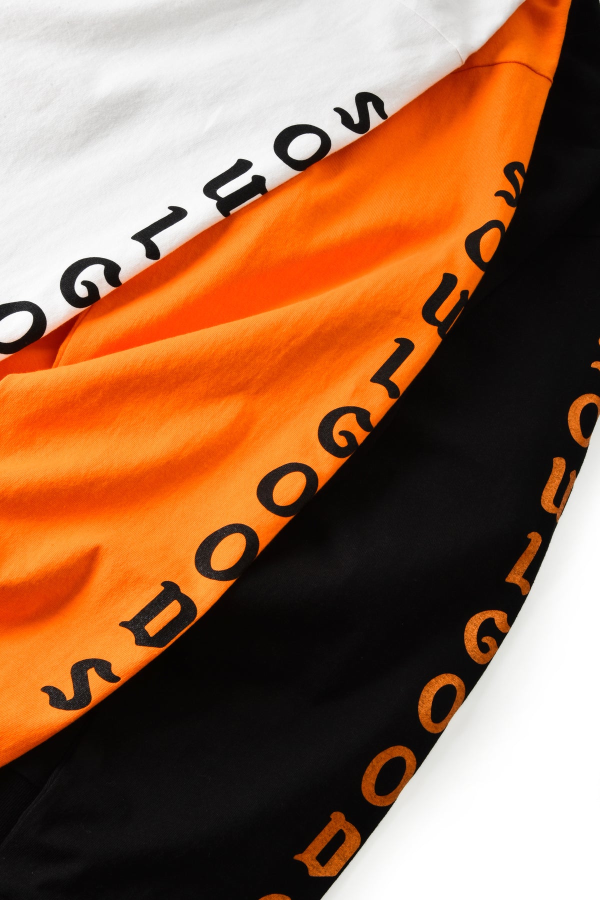 Close-up of fabric with 'SOULGOODS' branding in black on orange and black backgrounds.