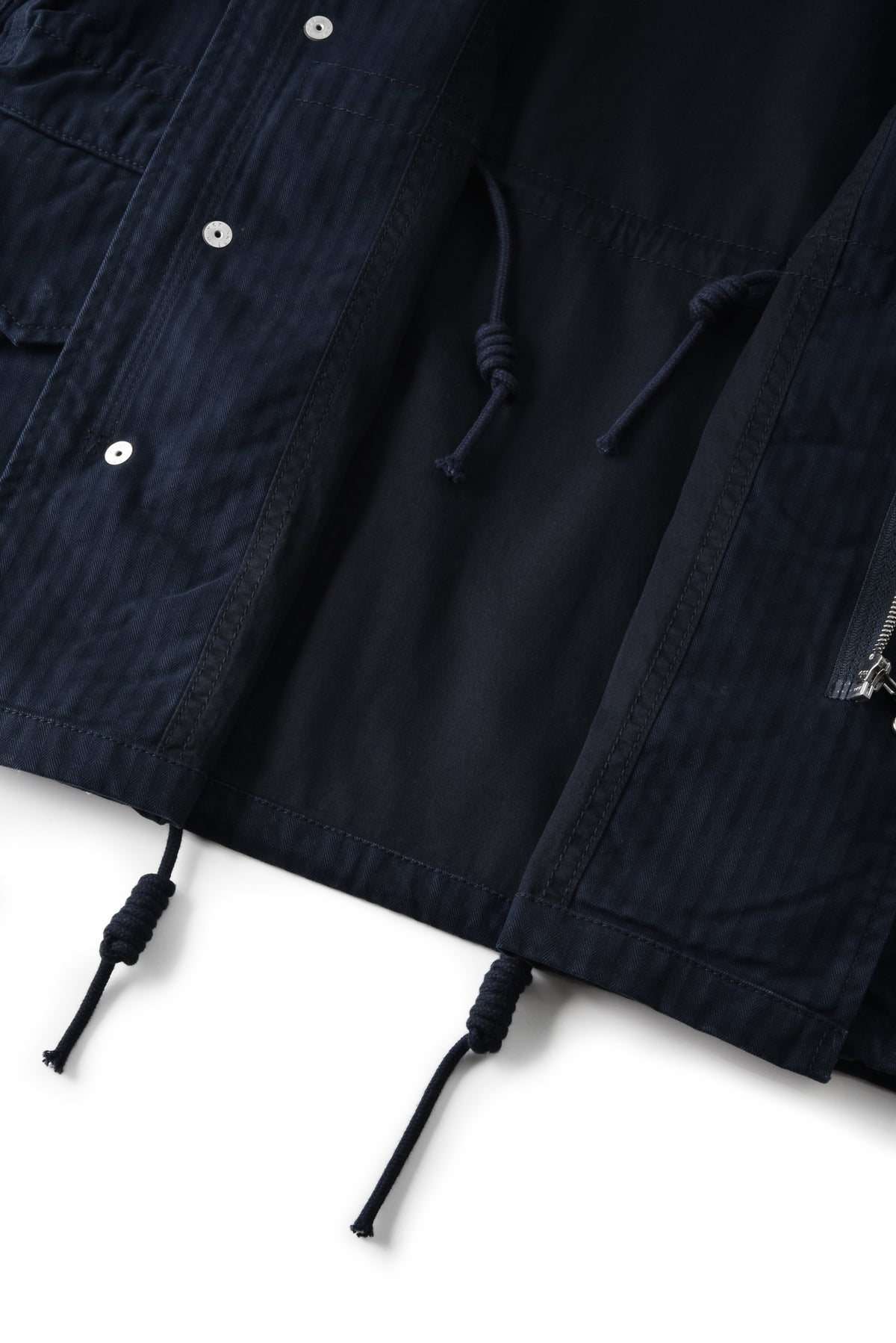 Close-up of a navy blue jacket with buttons and drawstrings on a white background
