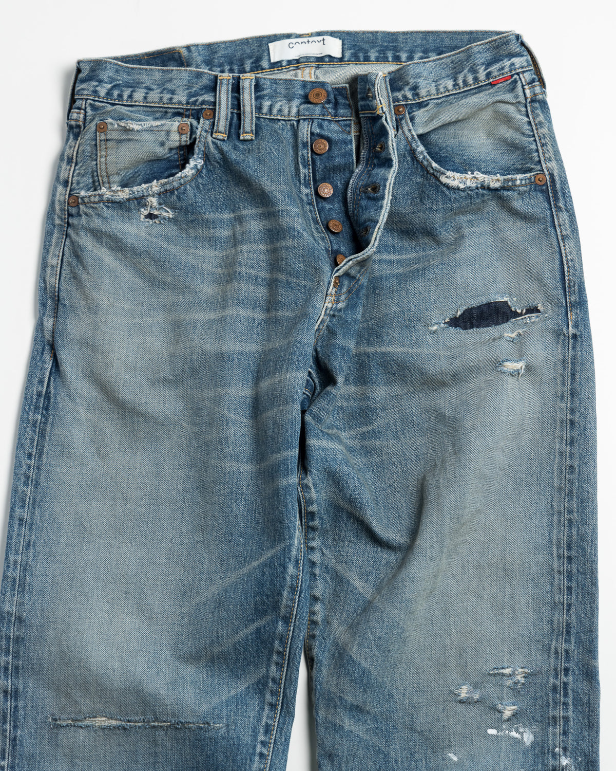 Pair of distressed blue jeans on a white background