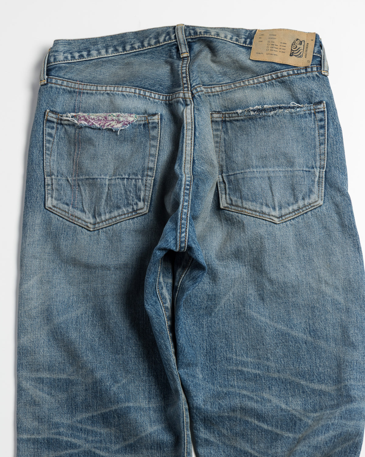 Blue denim jeans with a visible brand tag on a white background
