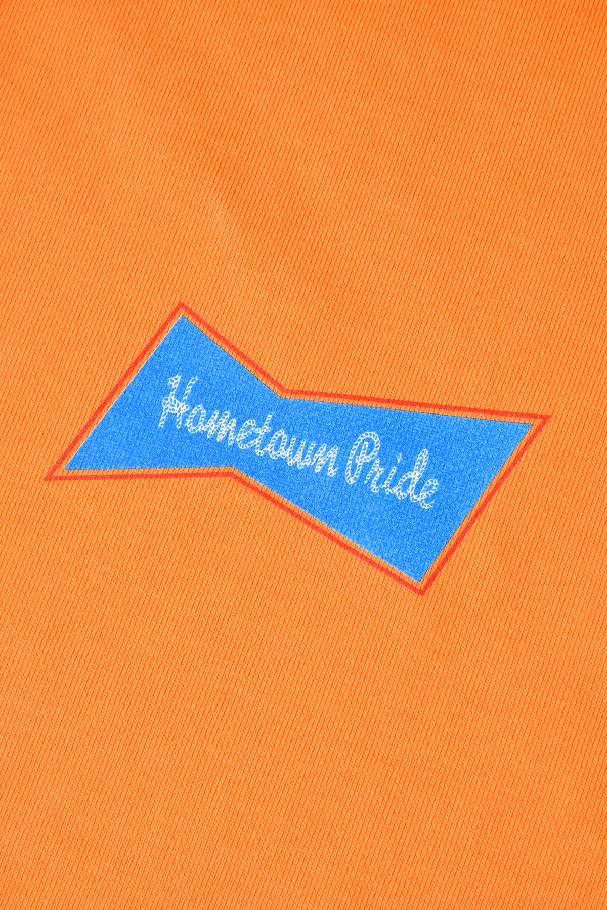 Orange fabric with 'Hometown Pride' embroidered in blue and white