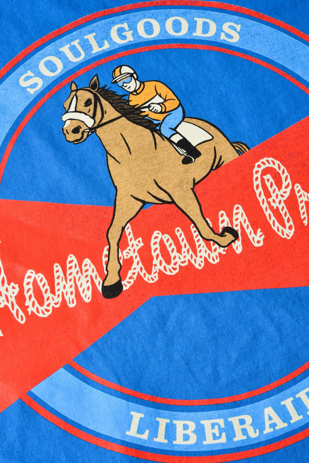 T-shirt with a horse and jockey graphic and 'Soulgoods' branding on a blue and red background.