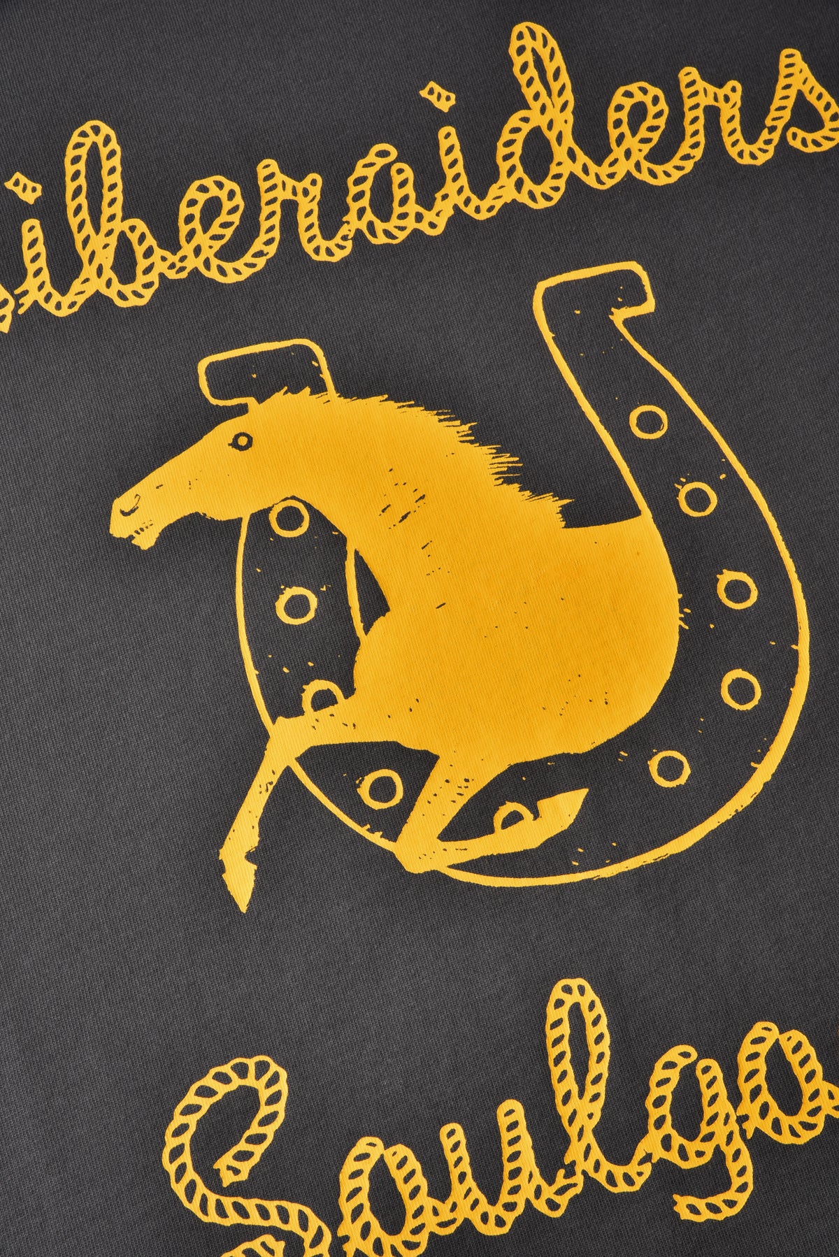 Black shirt with yellow graphic of a horse and horseshoe, and text 'Liberaiders Soulgoods'.