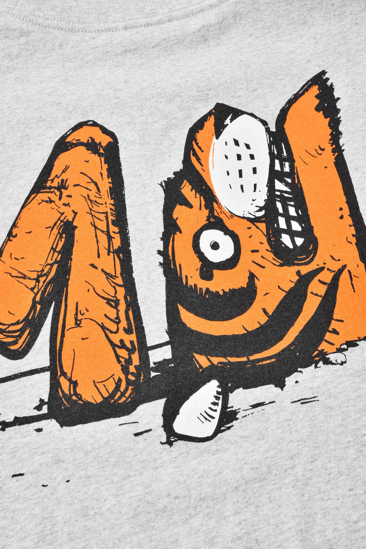 Close-up of a graphic design on a gray background, featuring orange and black elements.