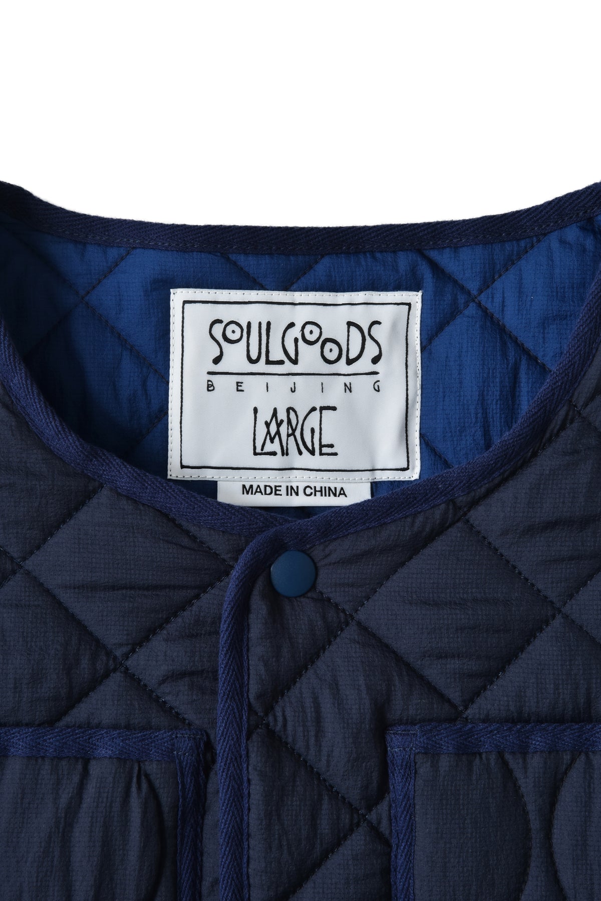 Navy quilted jacket with 'Soulgoods Beijing' label on a white background
