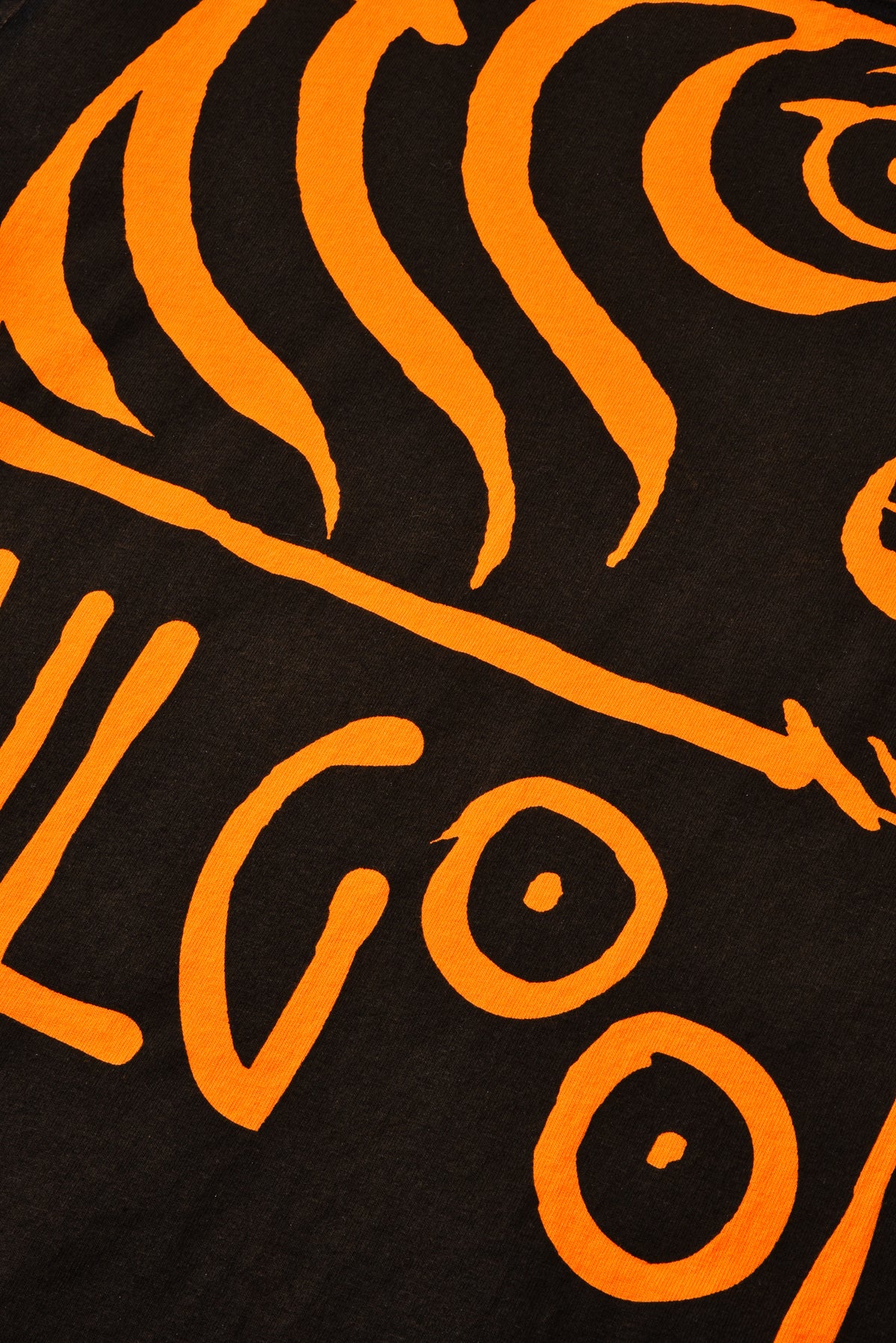 Close-up of a black and orange design with 'SOULGOODS' text on a dark background