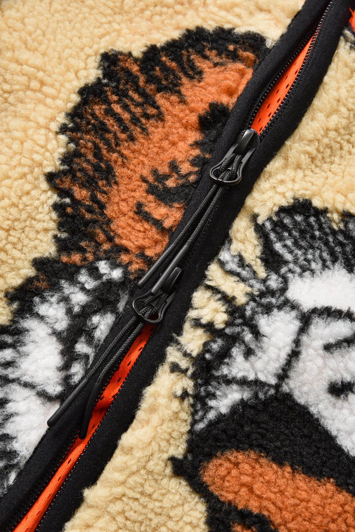 Close-up of a zipper on a textured fabric with a tiger design.