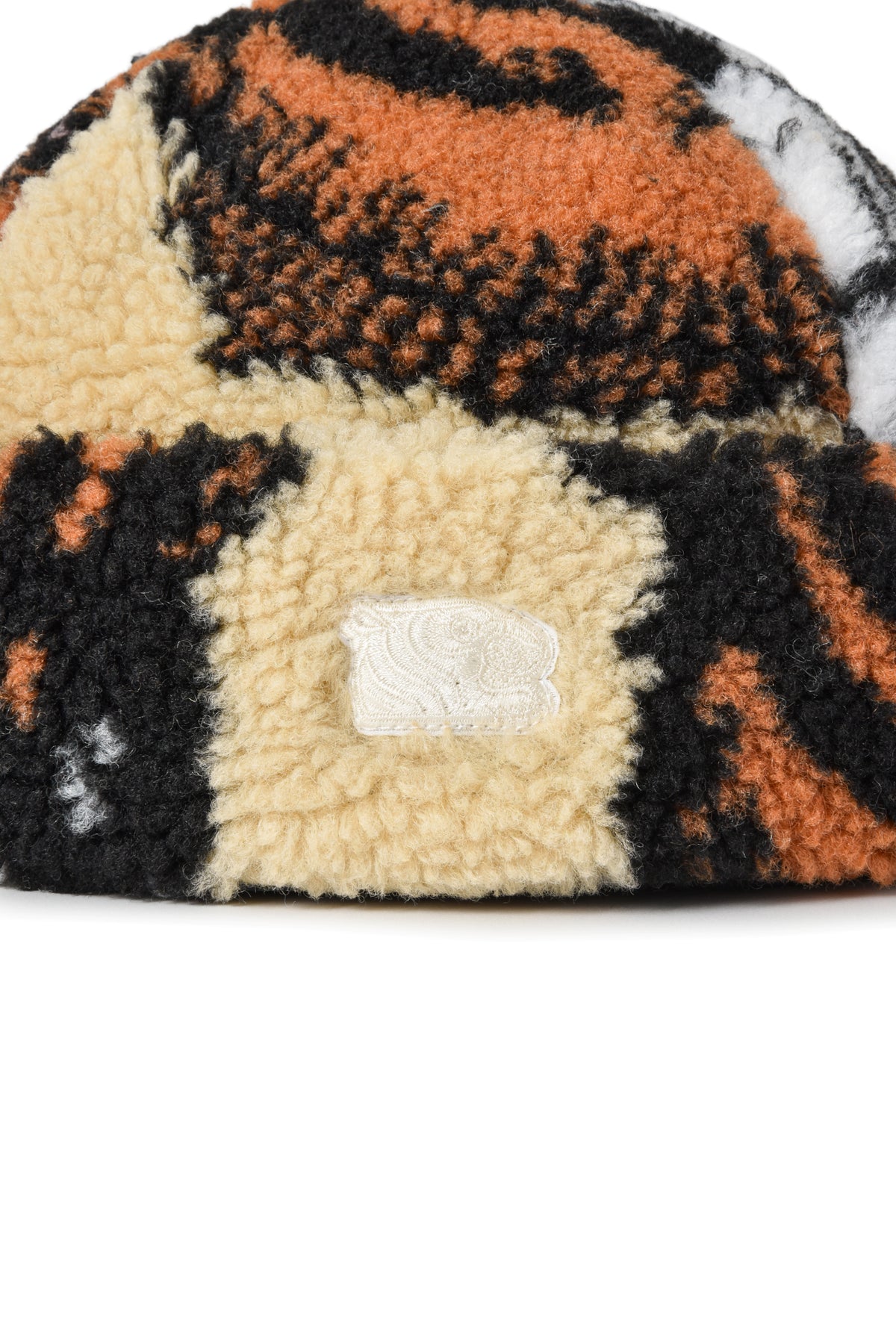 Fuzzy fabric with a tiger head pattern in orange, black, and beige on a white background