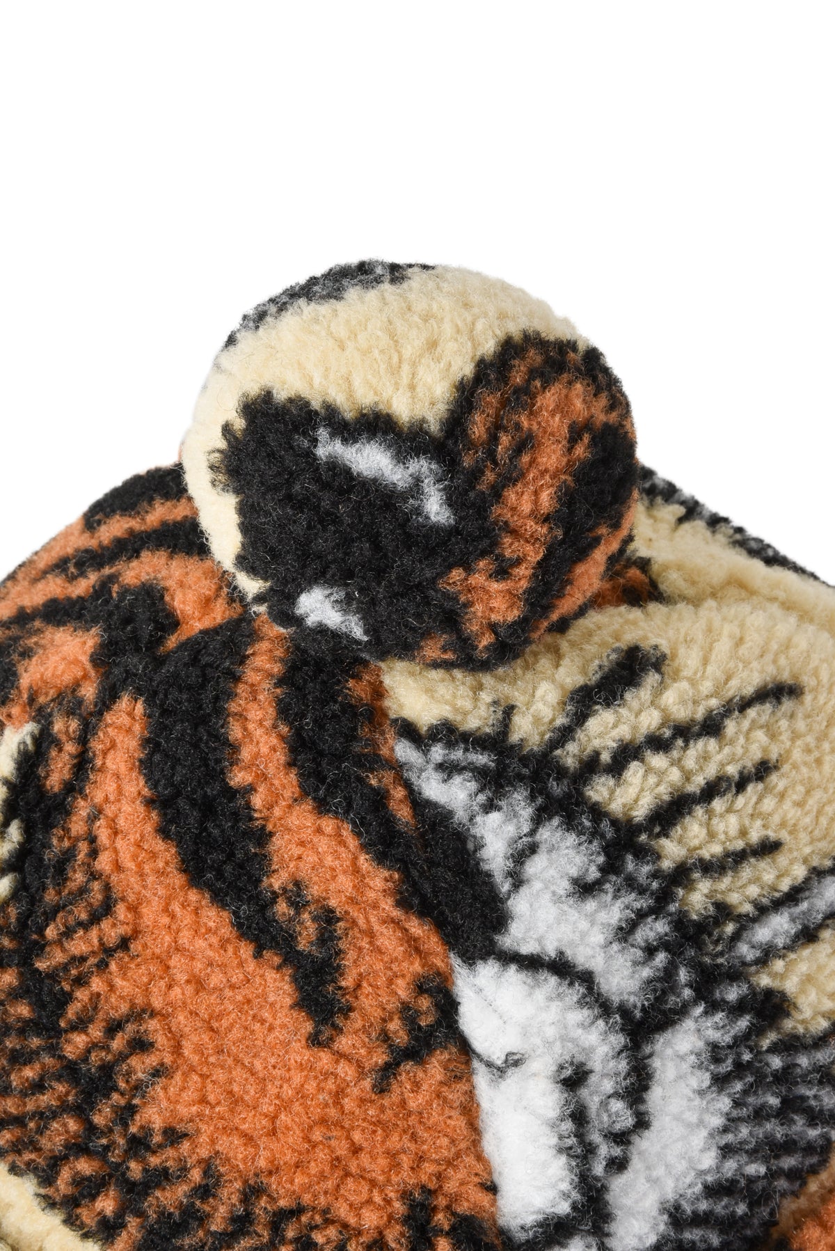 Close-up on pom-pom of a tiger-themed roll hat with a white background