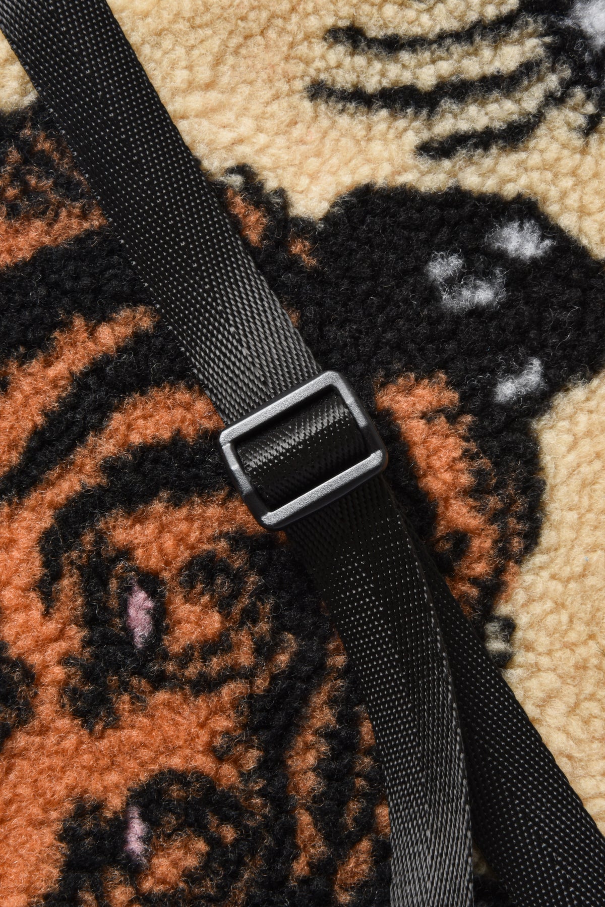 Black strap with a buckle on a textured surface with tiger pattern