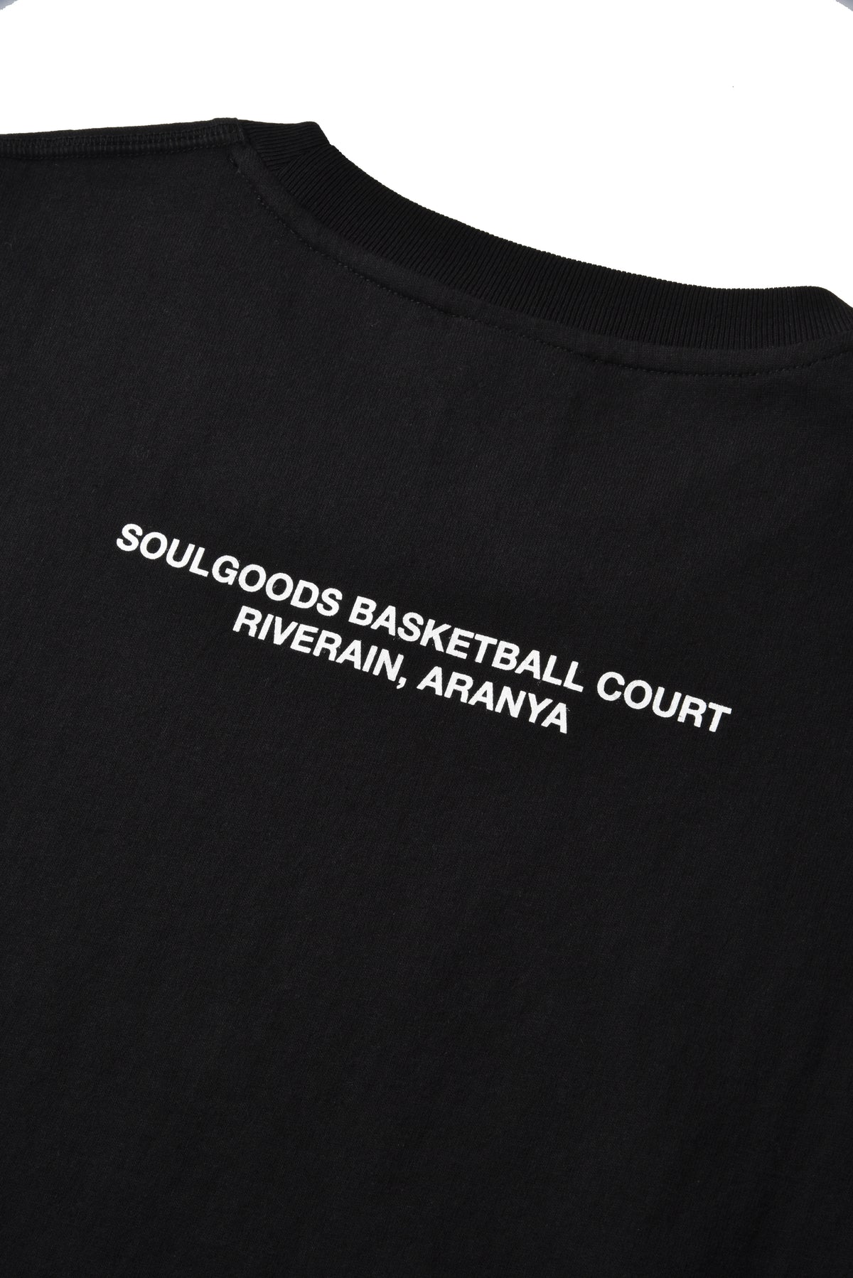 Close-up of a black t-shirt showing the back collar and upper back with white printed text that reads 'SOULGOODS BASKETBALL COURT RIVERAIN, ARANYA'.