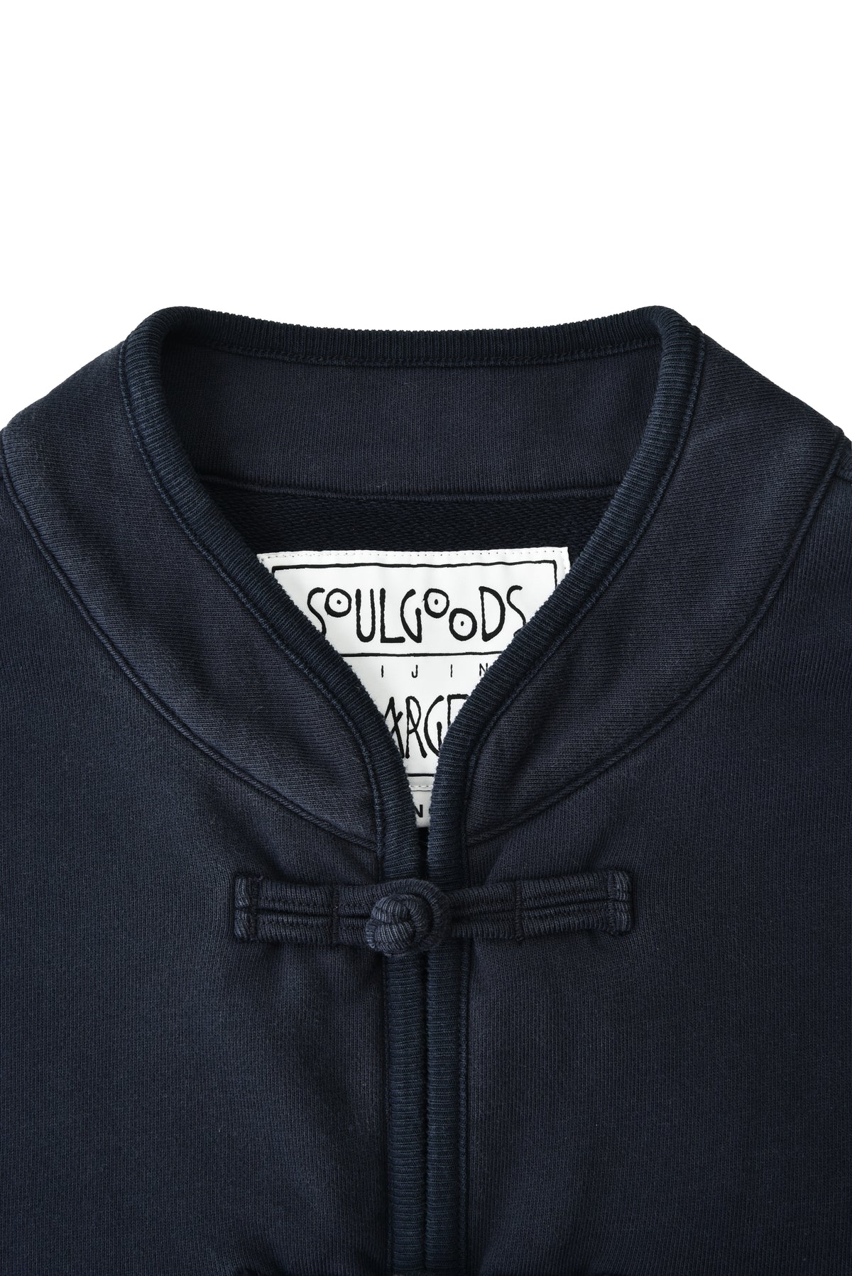 Close-up of a navy blue jacket with a SOULGOODS brand label on the collar.