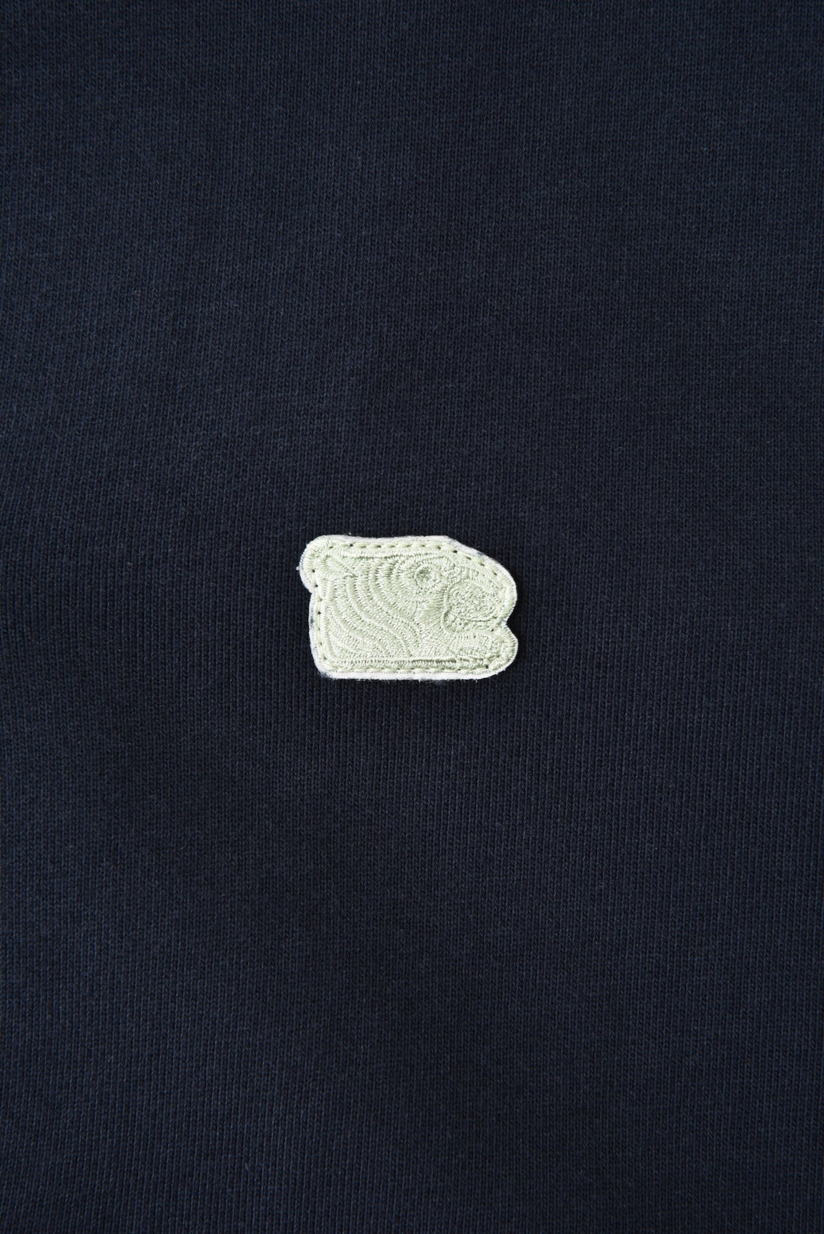 Small white soulgoods tiger head patch with a design on a black background