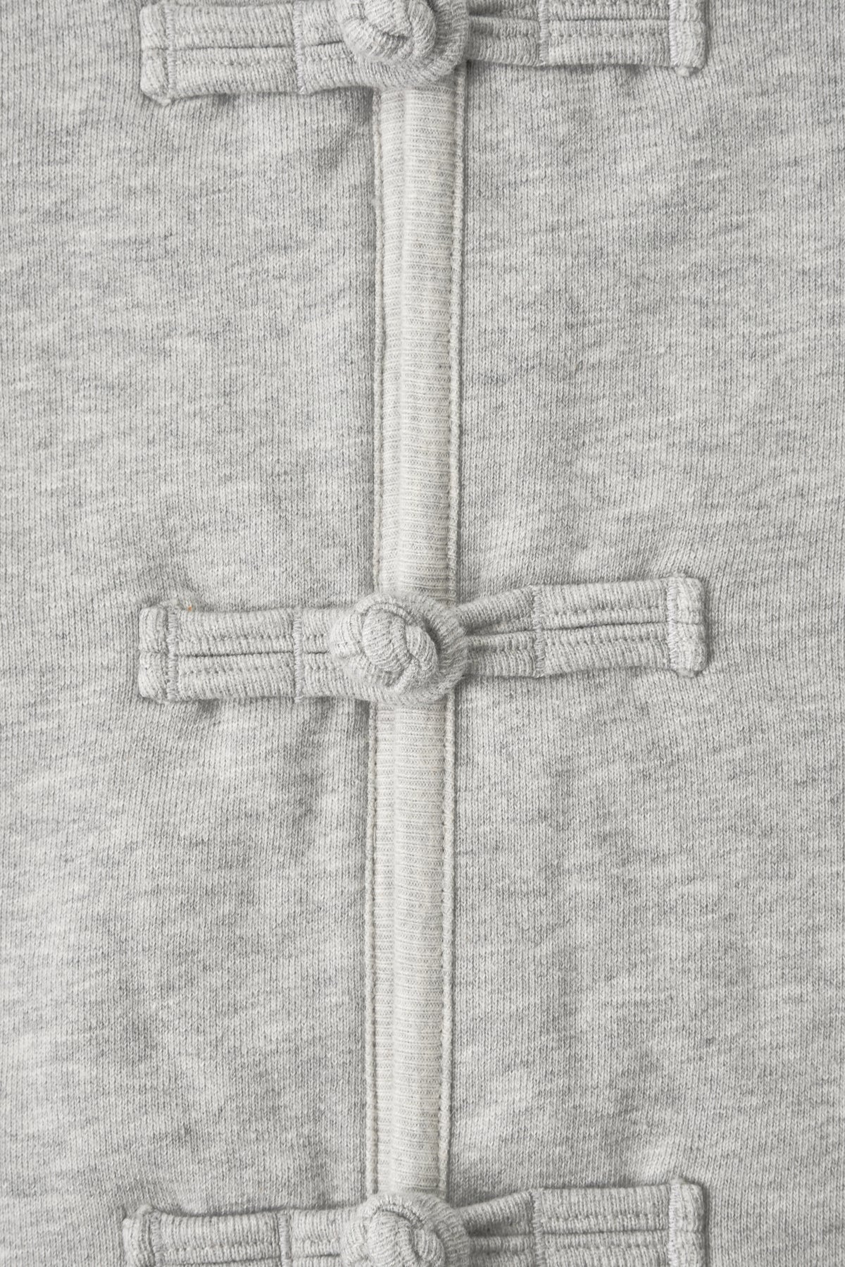 Close-up of a gray garment with a buttoned front