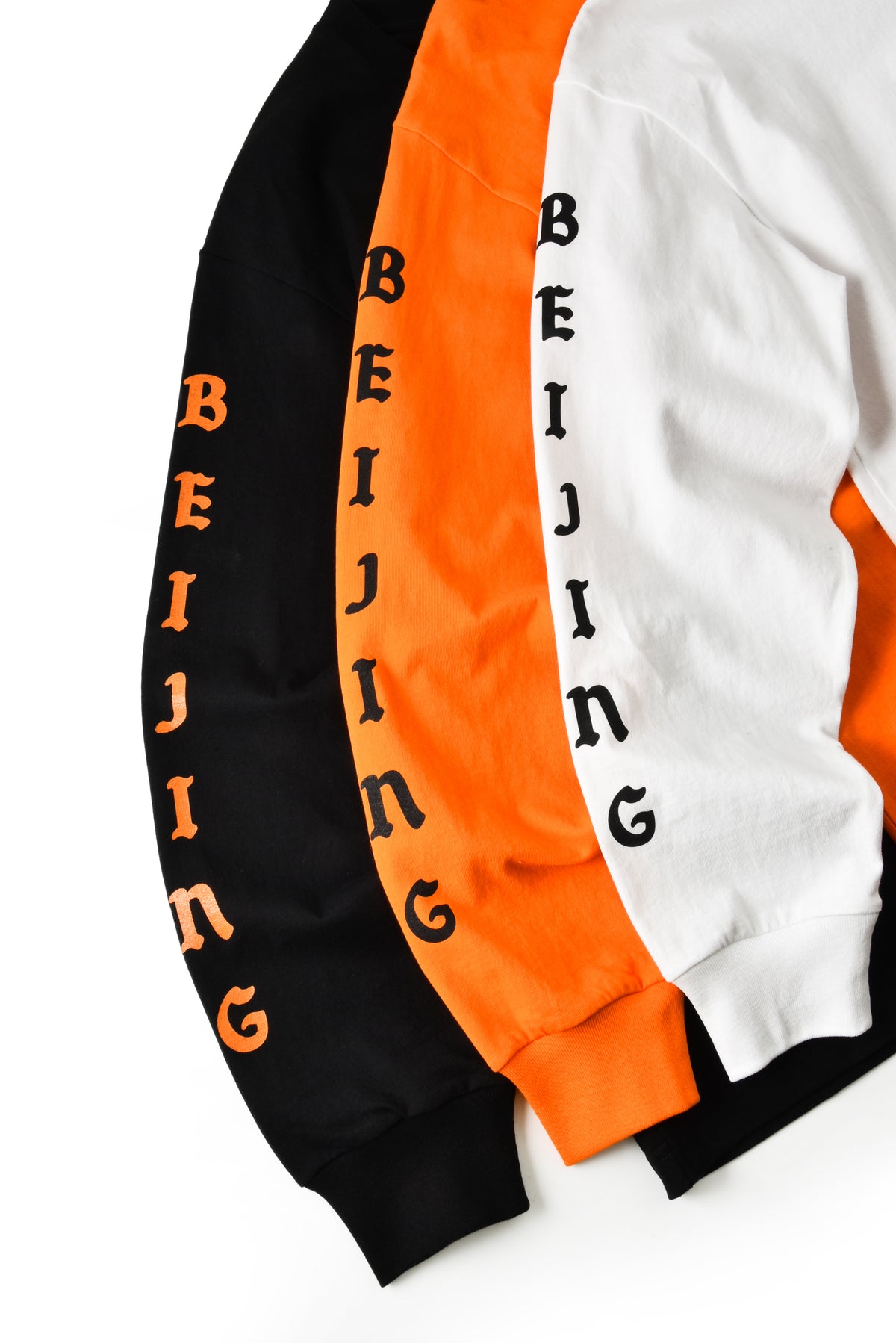 Three jackets in black, orange, and white with 'BEIJING' text on a white background