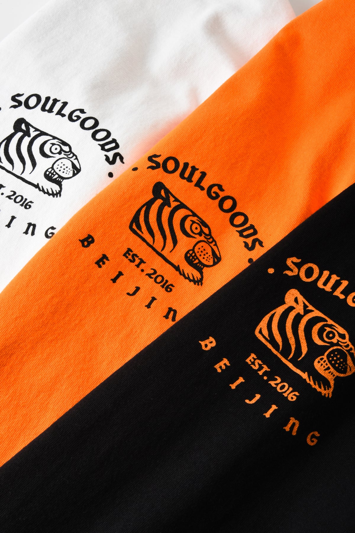 Close-up of orange and black clothing with 'Soulgoods Beijing' logo.