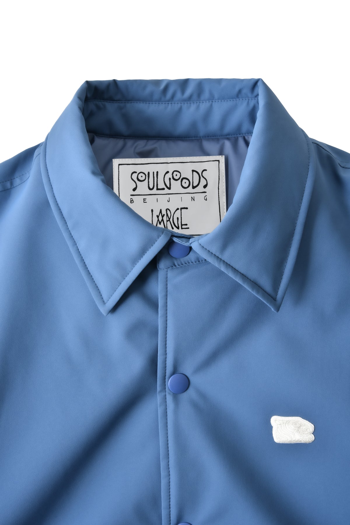 Blue jacket with a soulgoods brand label on a white background