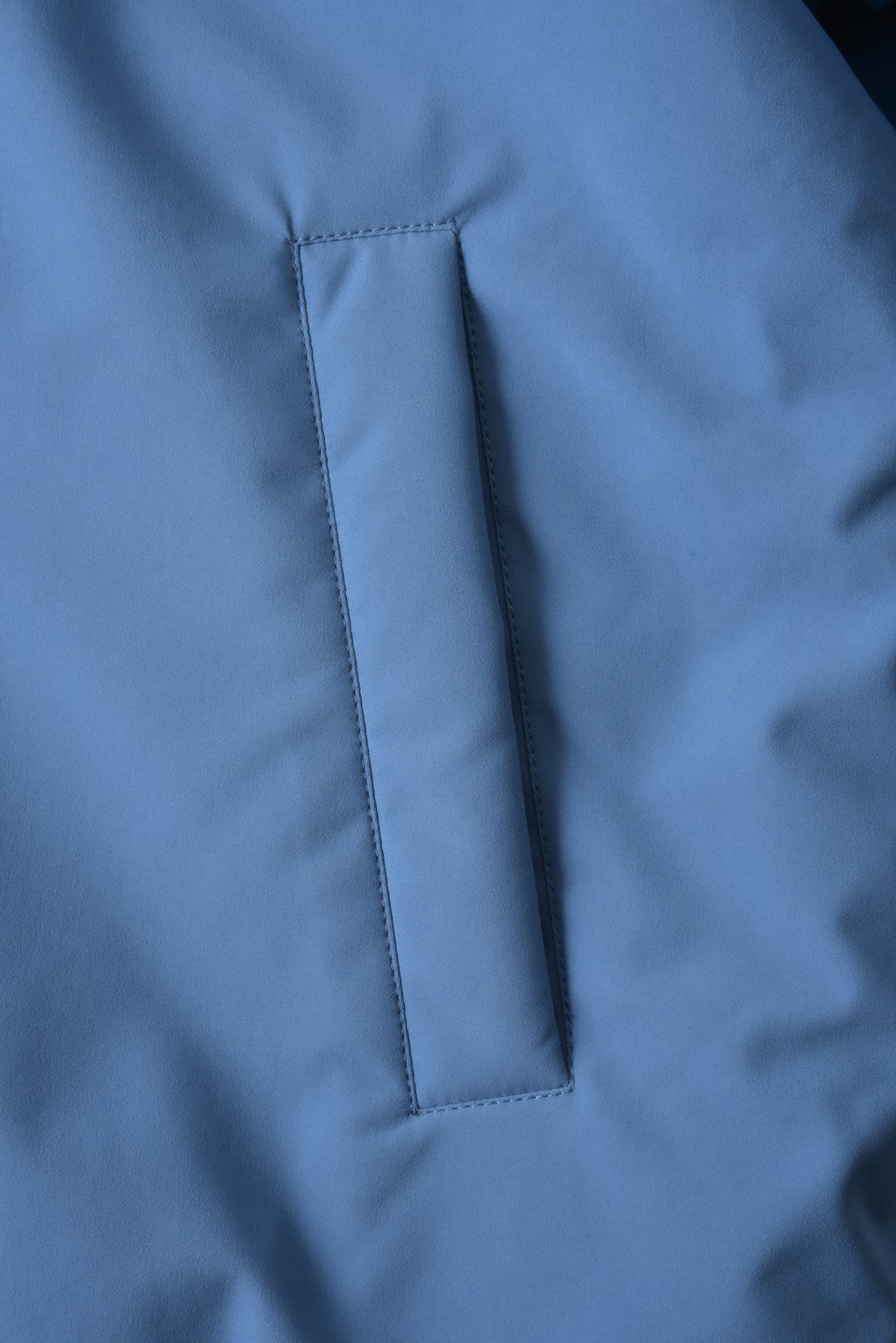 Close-up of a blue fabric texture with stitching detail