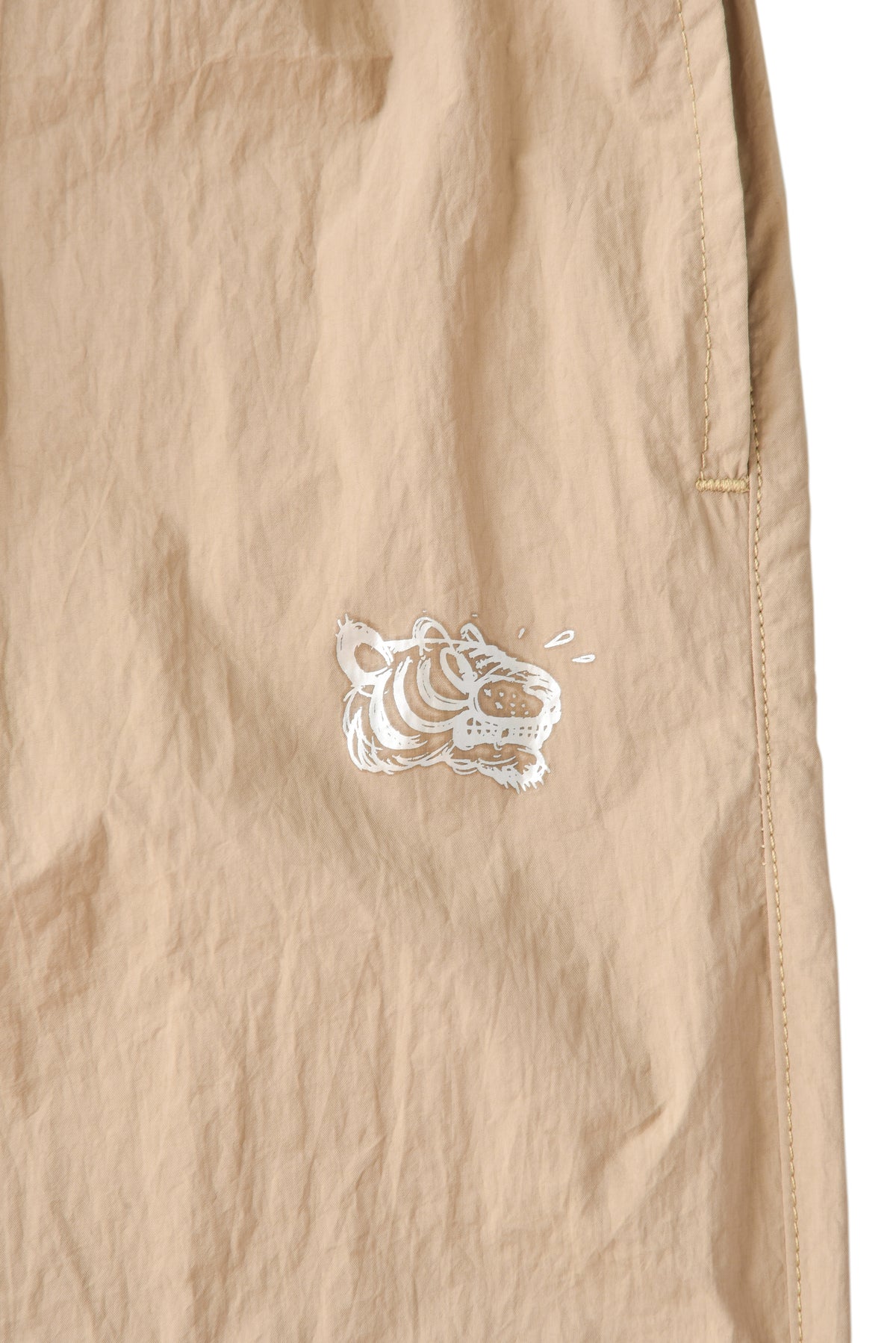 Beige pants with a white soulgoods tiger logo on a white background