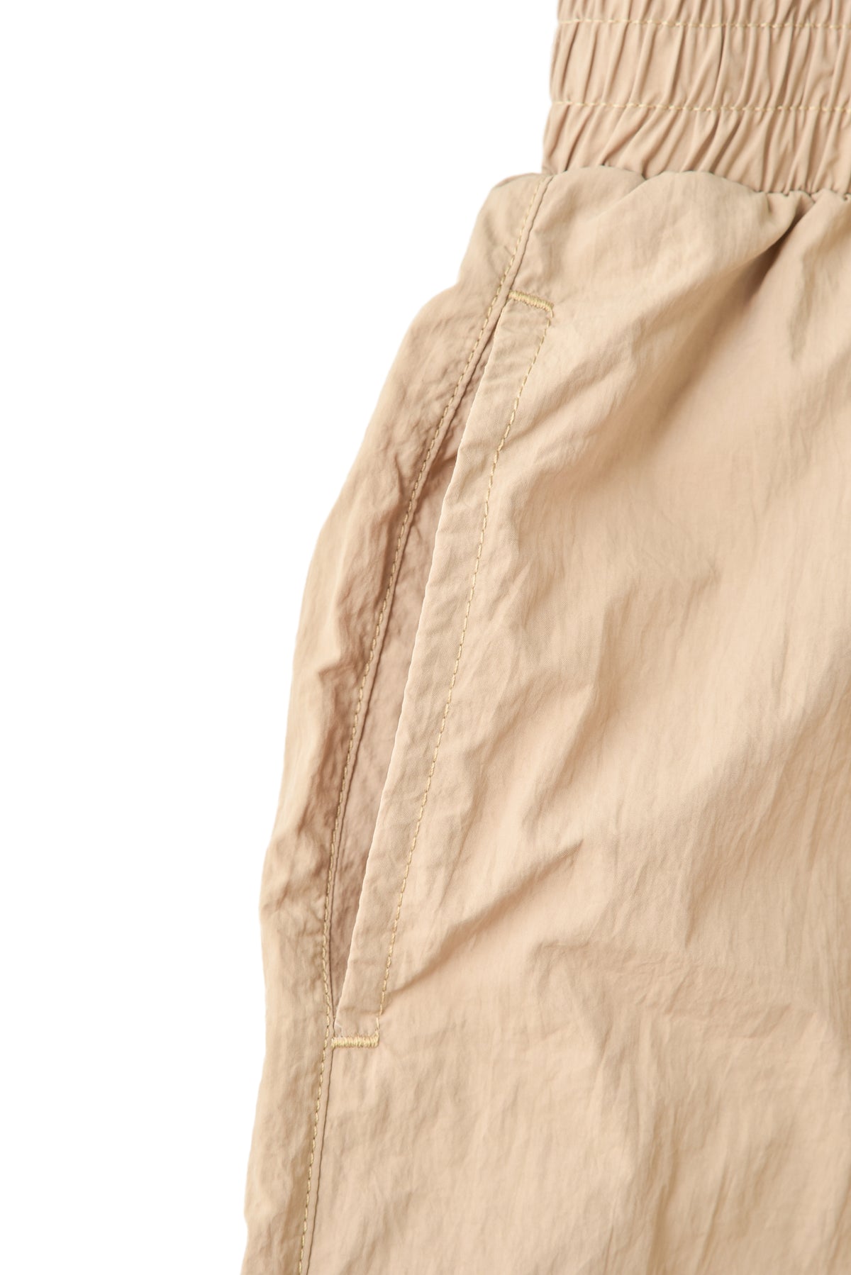 Close-up of beige pants with a white background