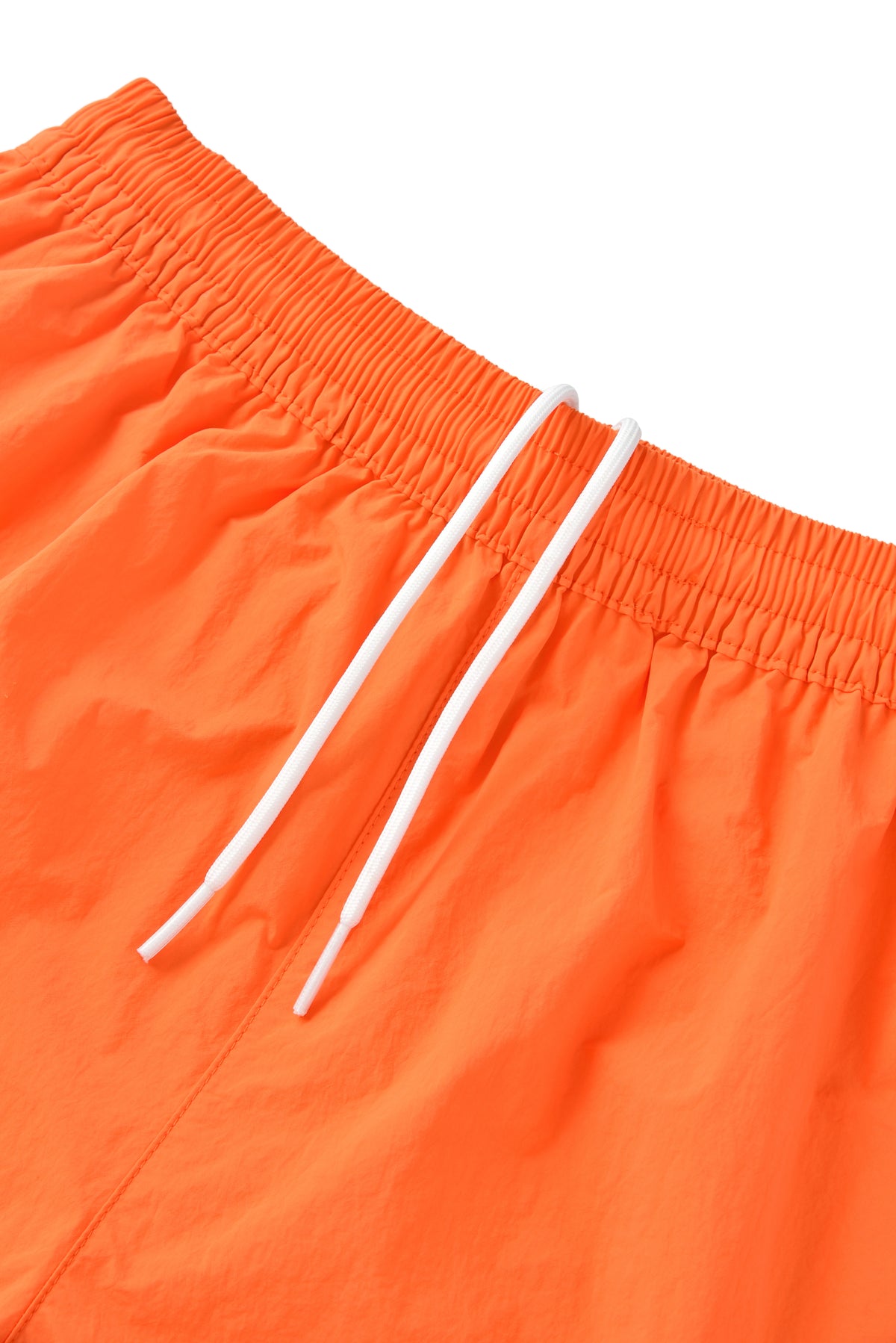 Close-up of orange shorts with white drawstring on a white background
