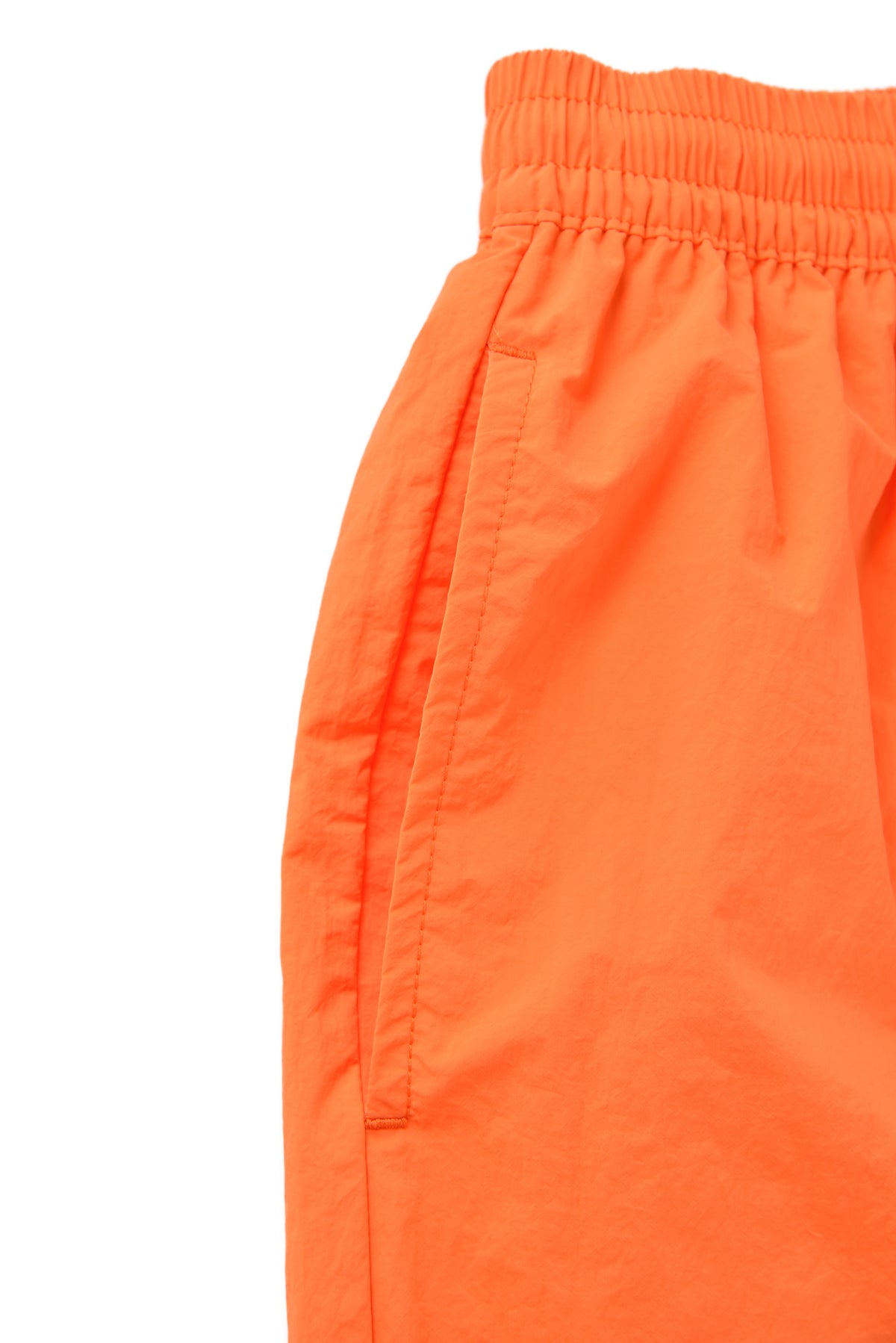Close-up of bright orange shorts on a white background