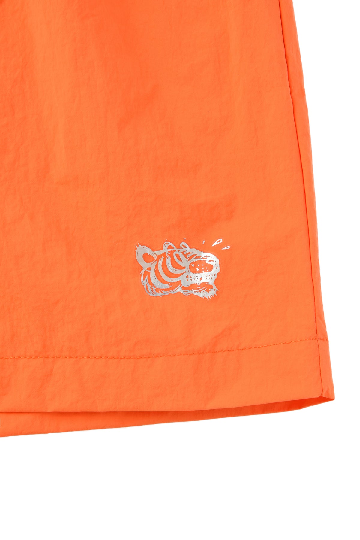 Close-up of an orange garment with a soulgoods tiger logo on a white background