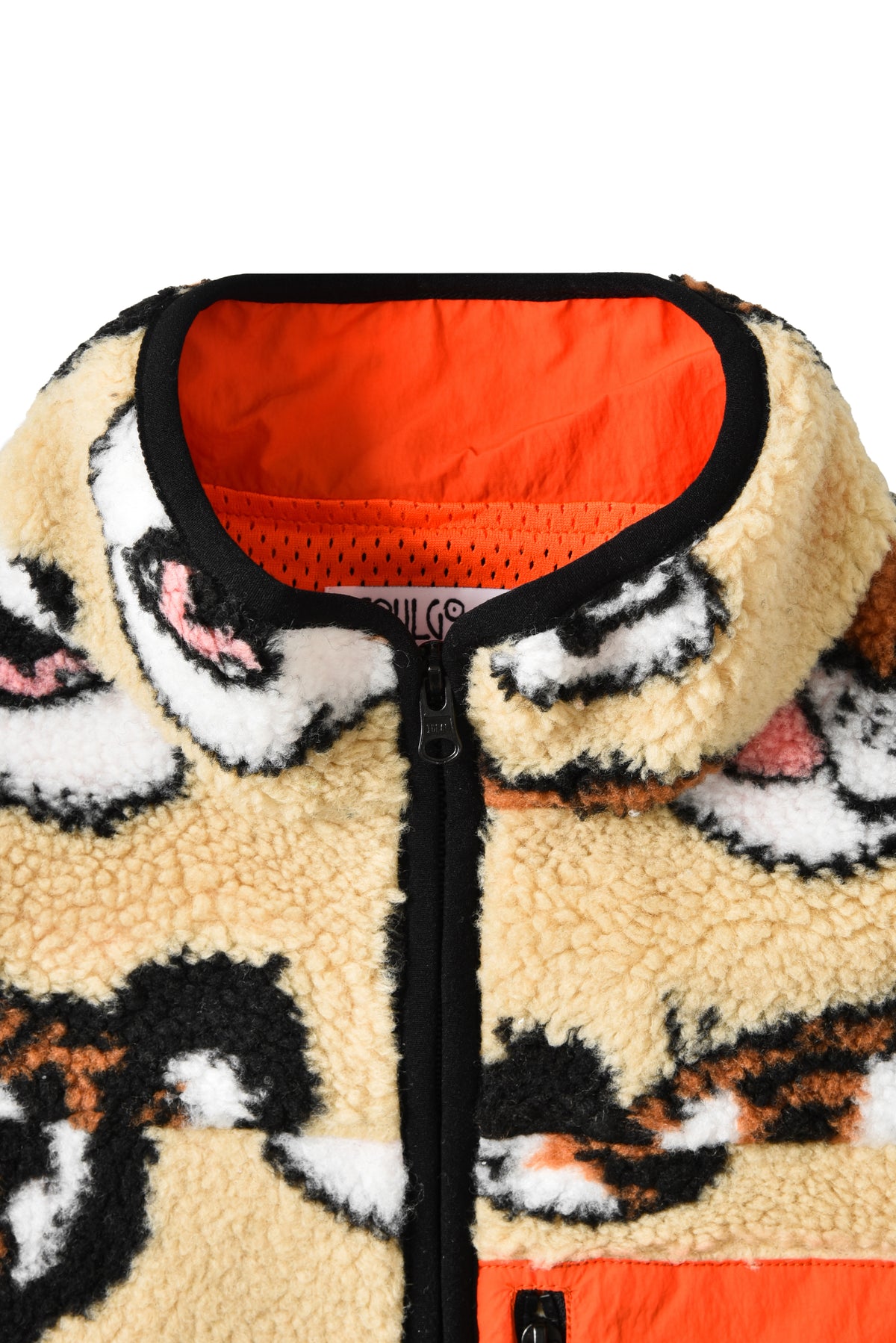 Close-up of a fleece jacket with animal pattern and orange interior lining.