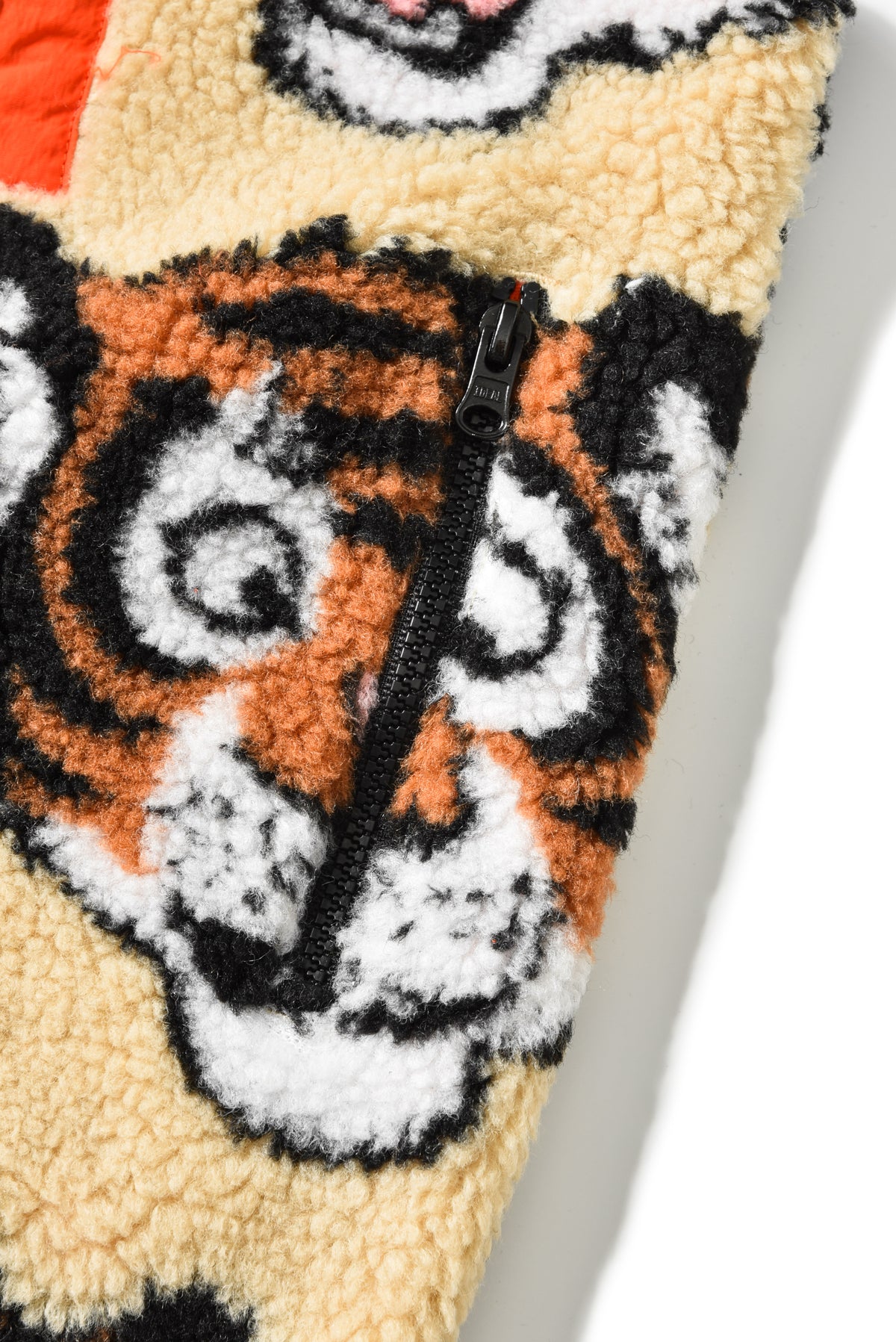 Close-up of a textured fabric with a tiger design and zipper.