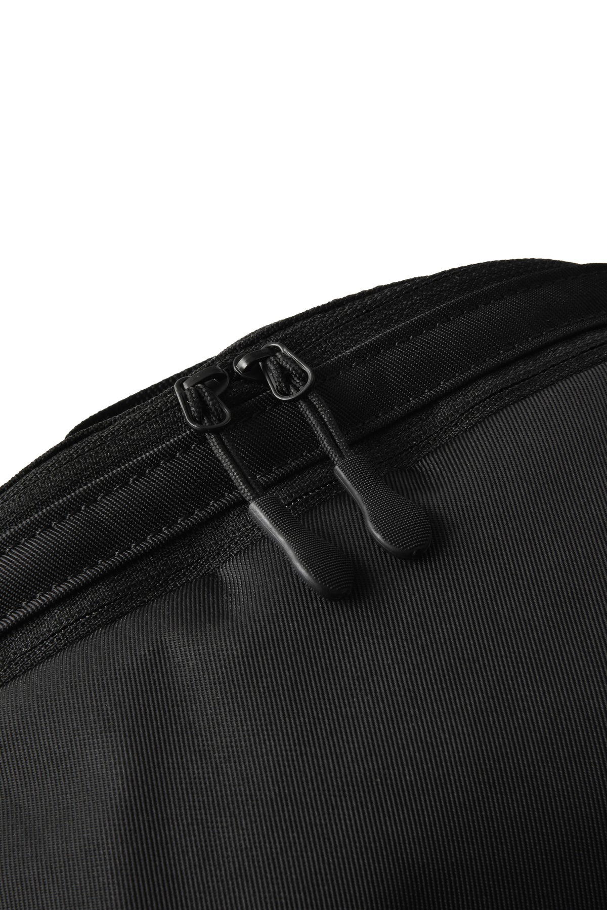 Close-up of a black textured fabric bag with a black zipper and dual black zipper pulls on a white background.