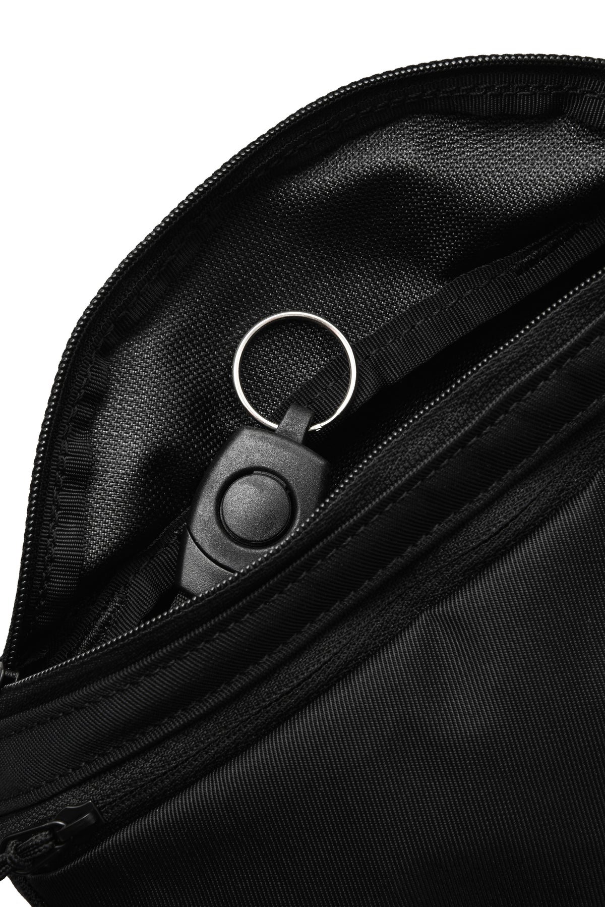Close-up of a black nylon bag with an open zipper, showing a black plastic keychain lock with a silver key ring inside a zippered pocket.