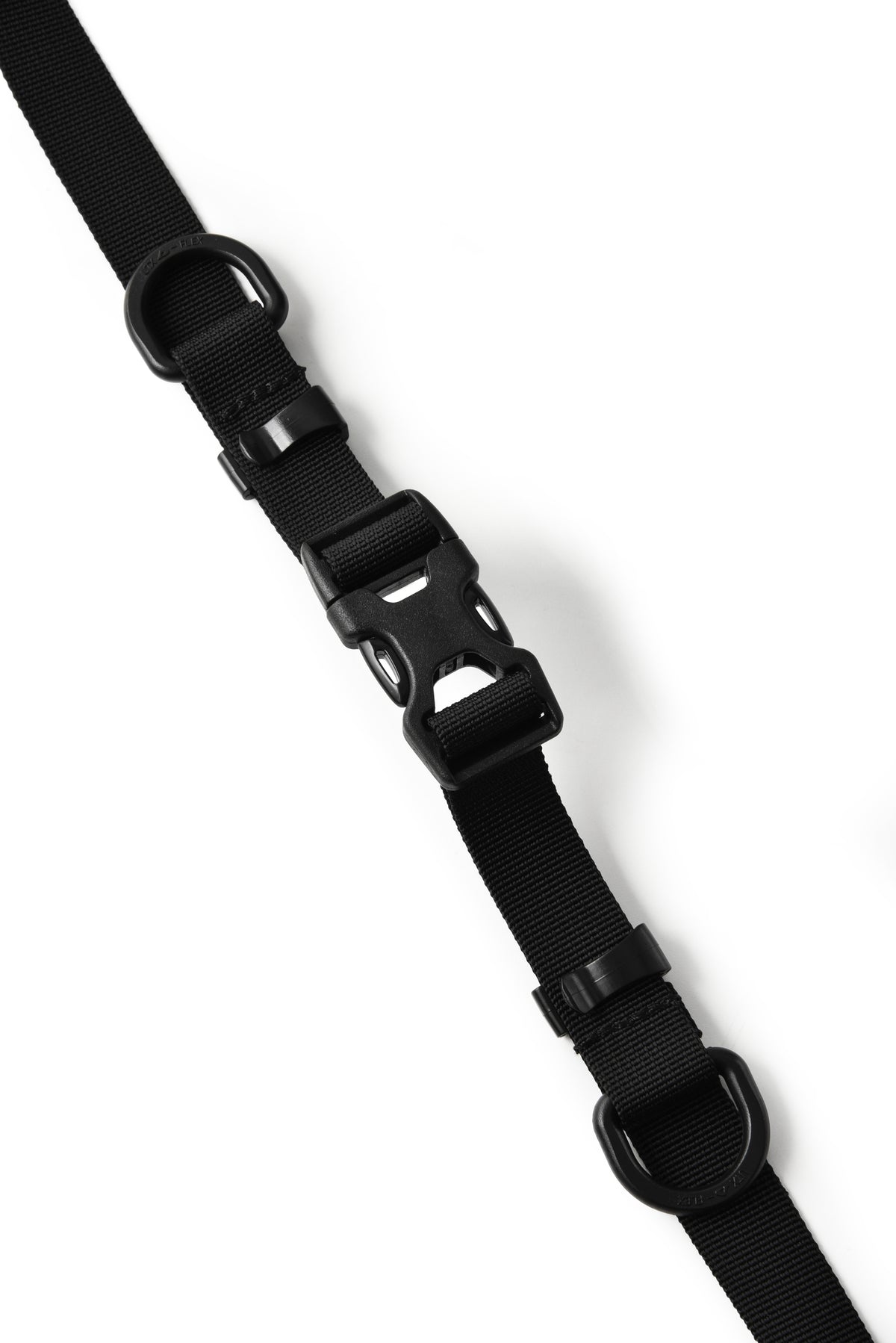 A close-up of a black nylon web strap with a black plastic quick-release buckle, shown diagonally on a plain white background.