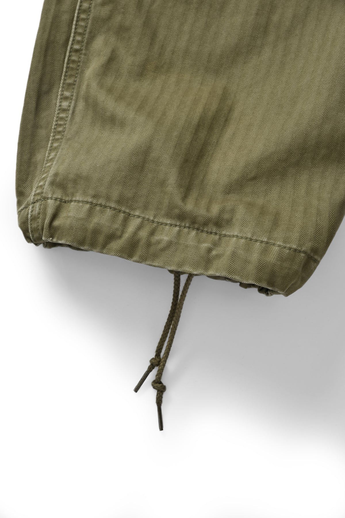 Close-up of a green jacket with a drawstring on a white background