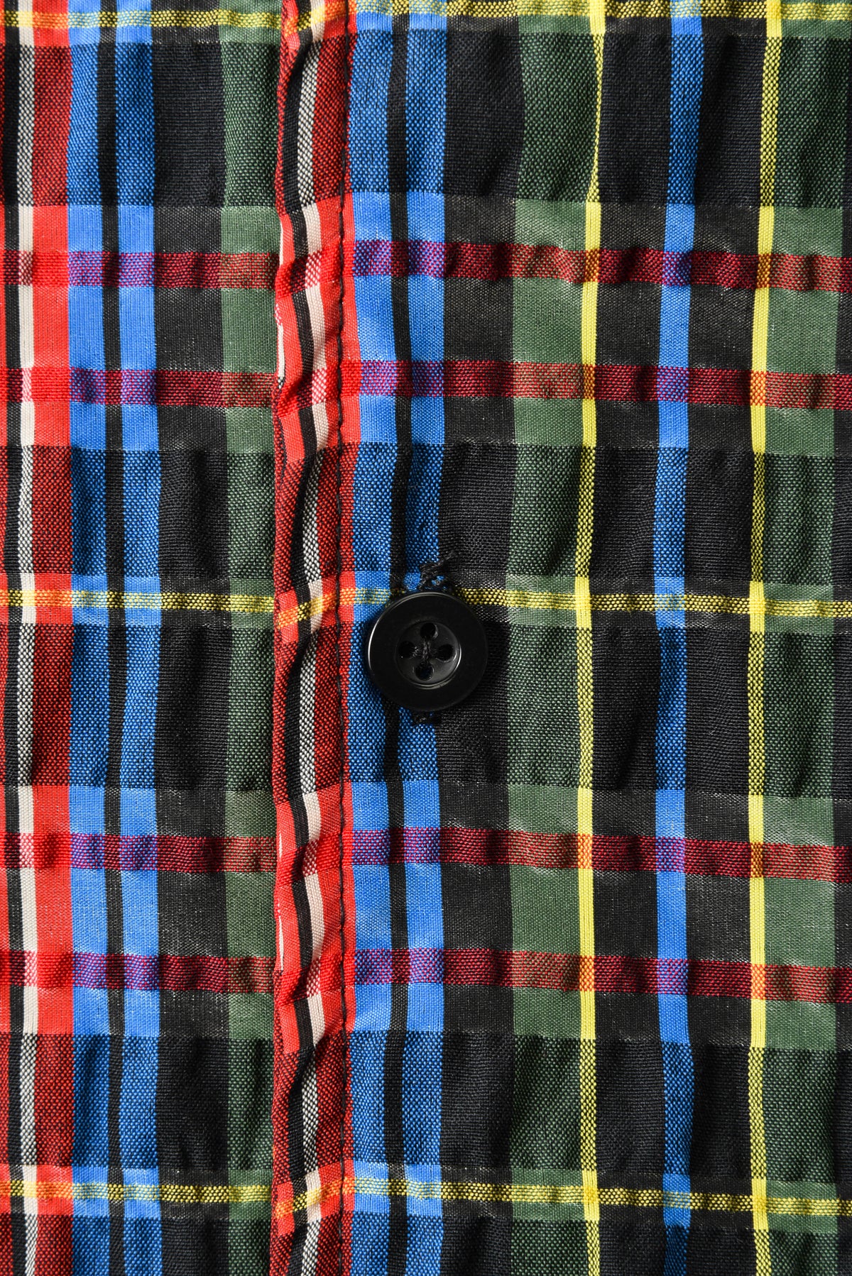Close-up of a plaid shirt with red, blue, green, and yellow colors.
