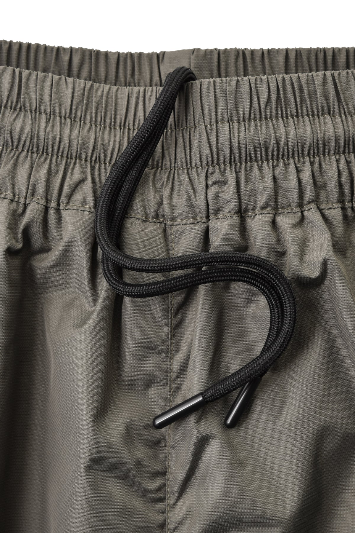Close-up of a green pants with a black drawstring on a white background