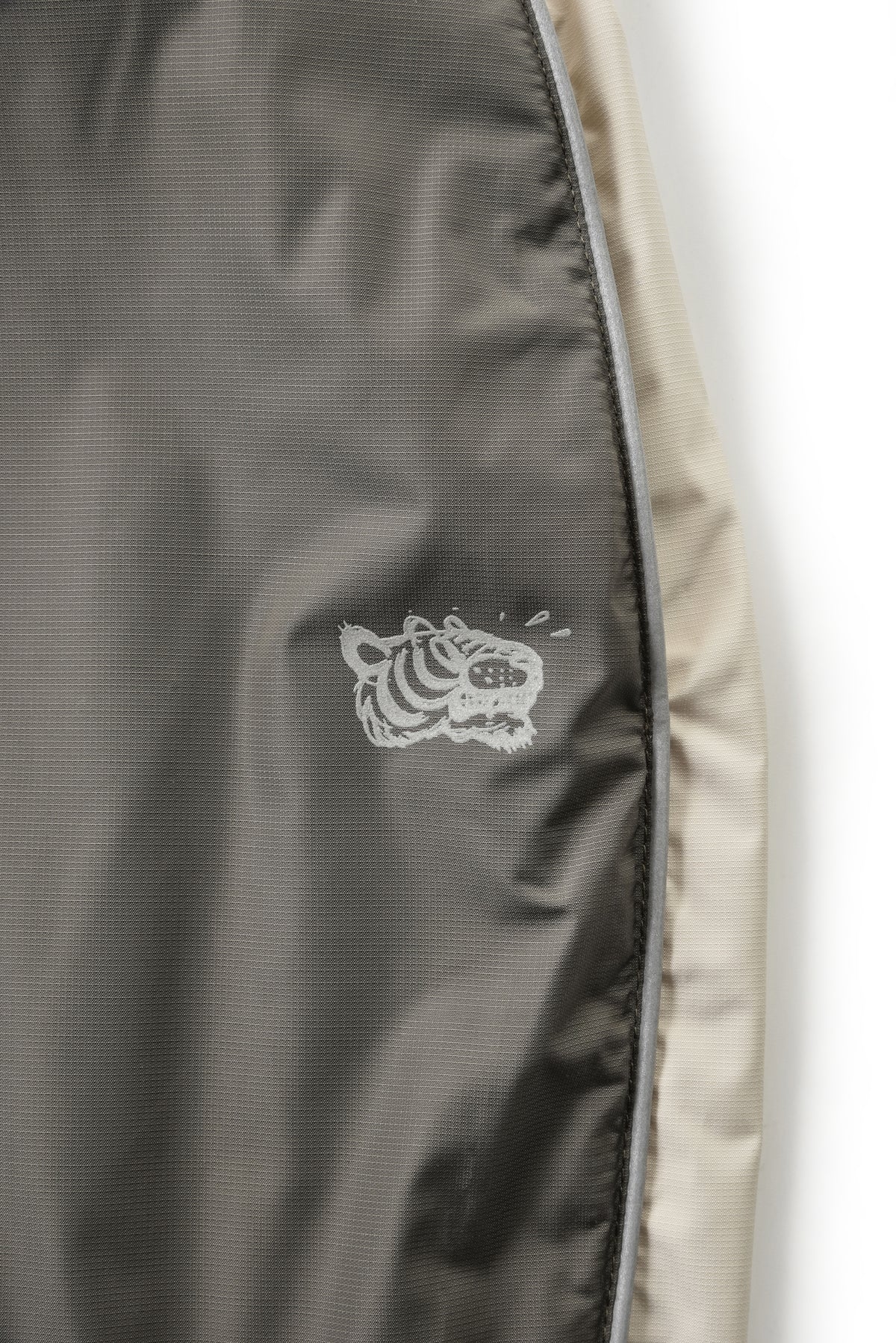 Close-up of a jacket with a soulgoods tiger head logo on a white background