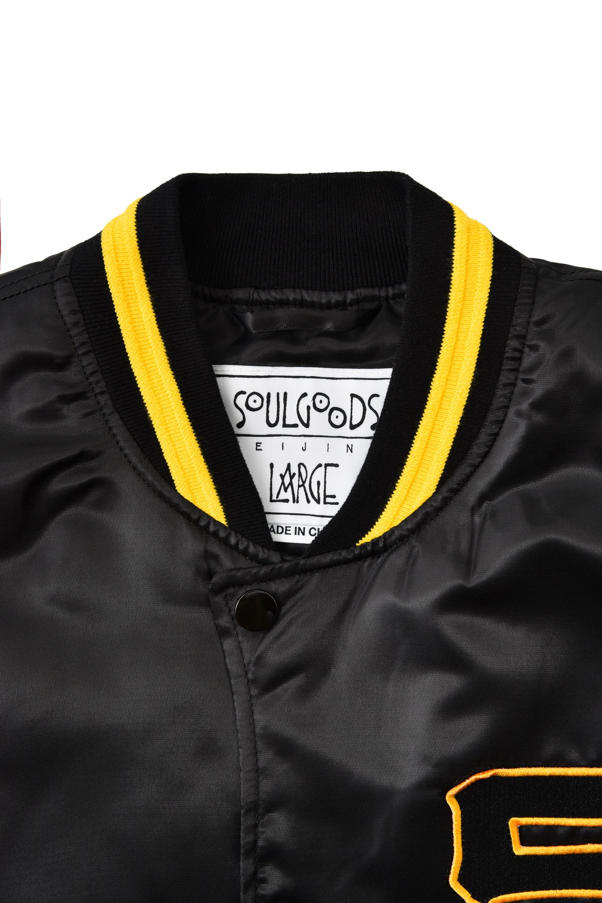 Black jacket with yellow trim and a visible SOULGOODS brand label on a white background