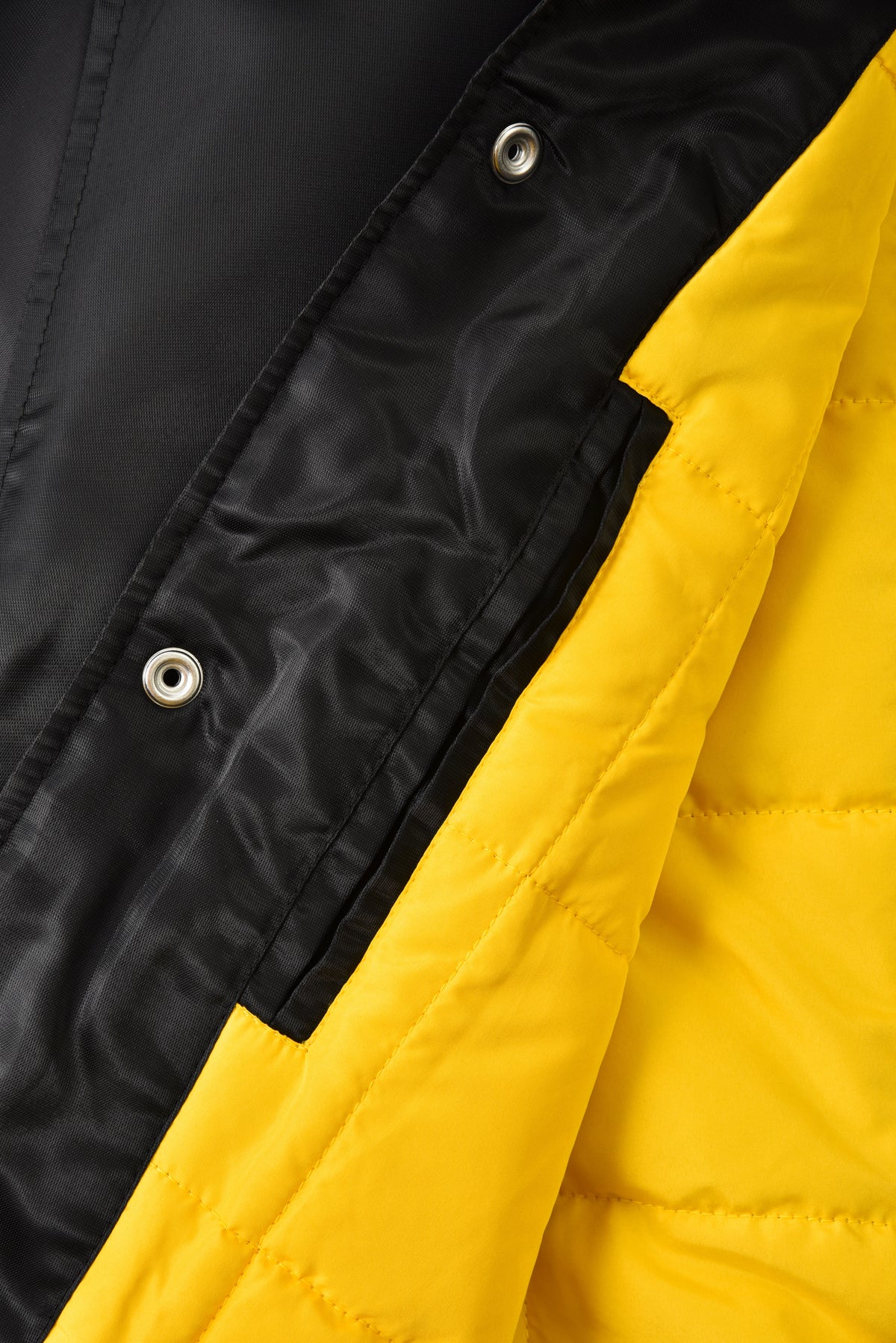 Close-up of a black and yellow jacket with button details