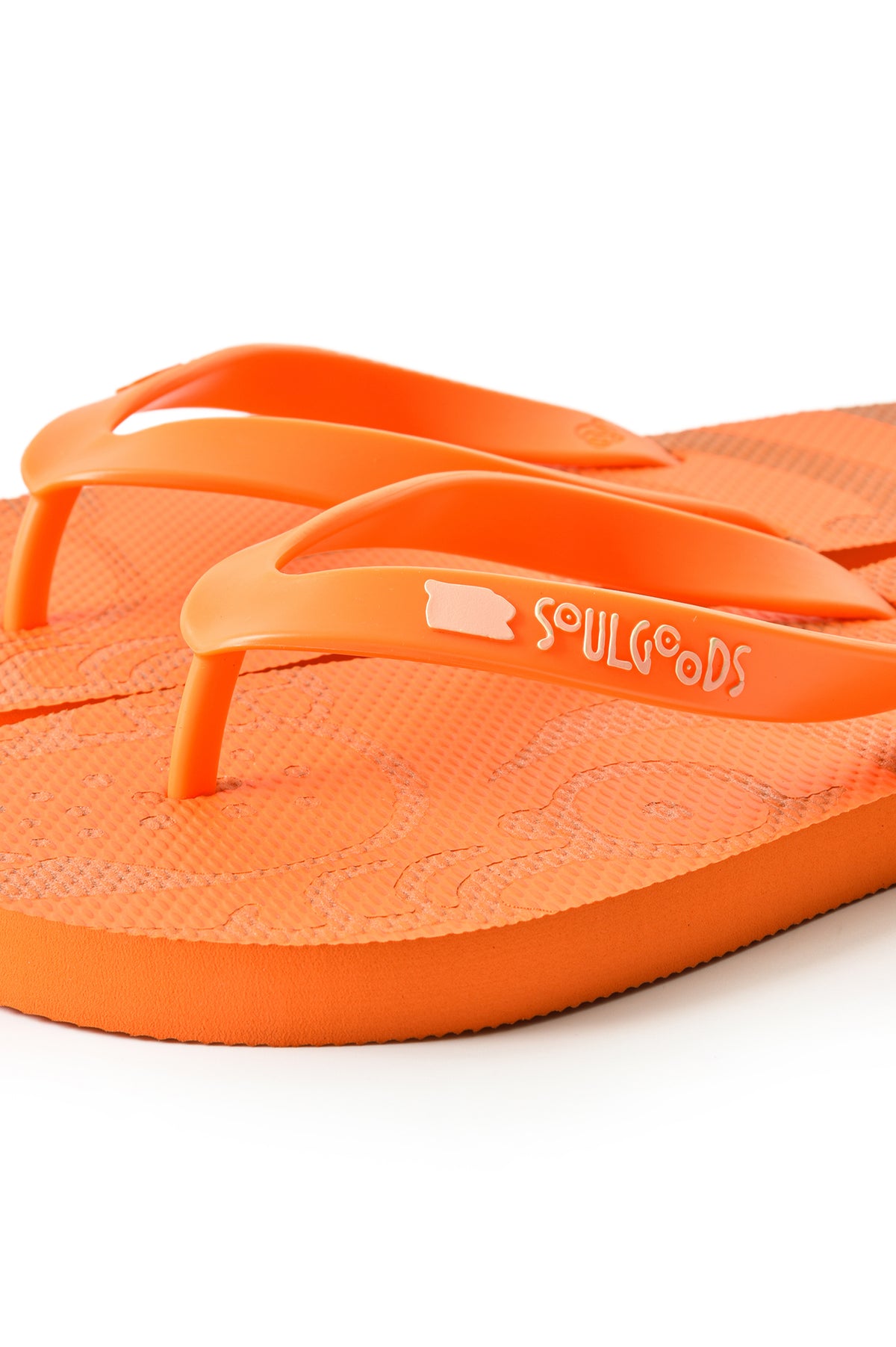 Bright orange flip-flop sandals by SoulGoods, featuring a textured footbed and a matching strap with the brand name, soulgoods, printed in white.