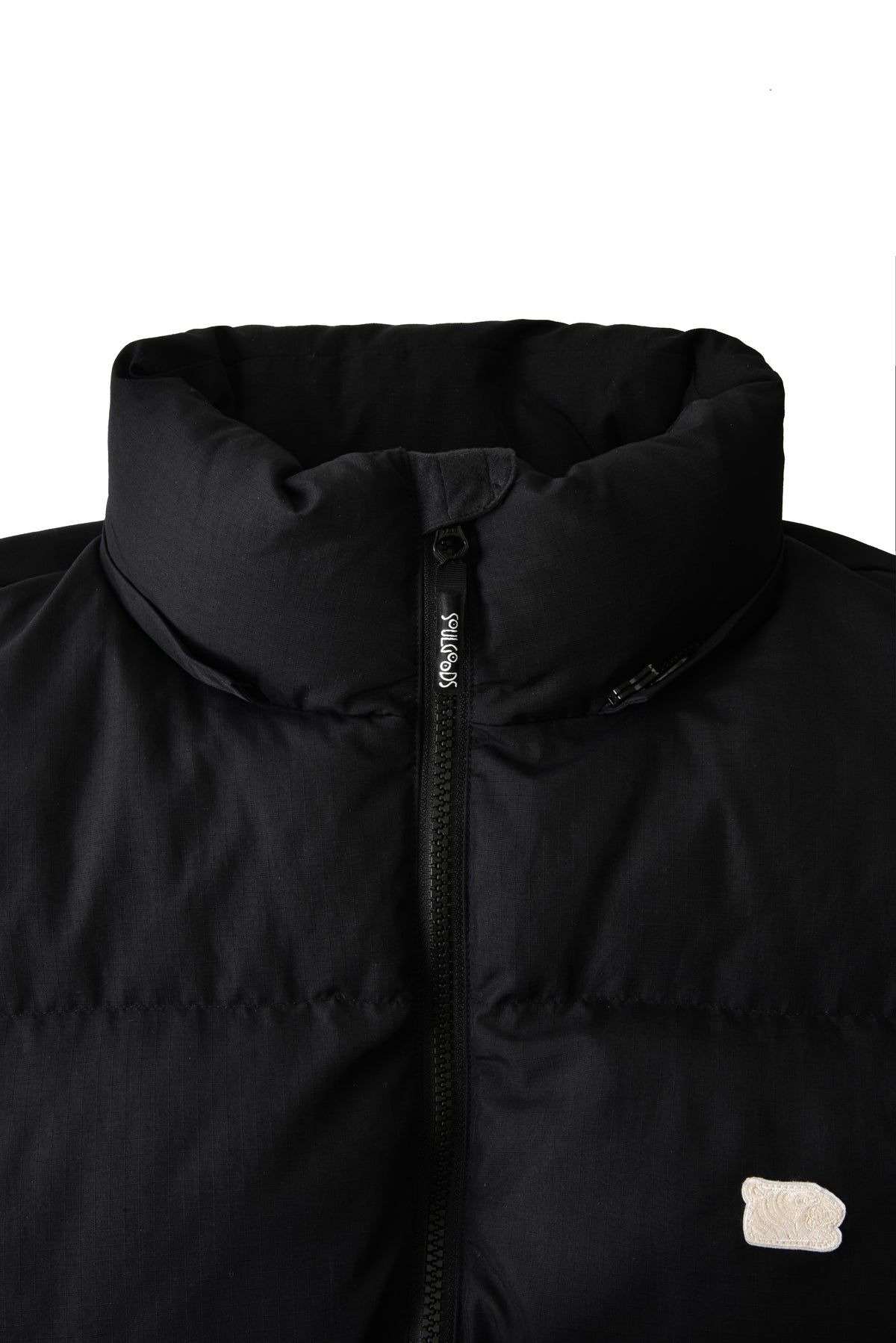 Close-up of a black jacket with a soulgoods brand logo on a white background