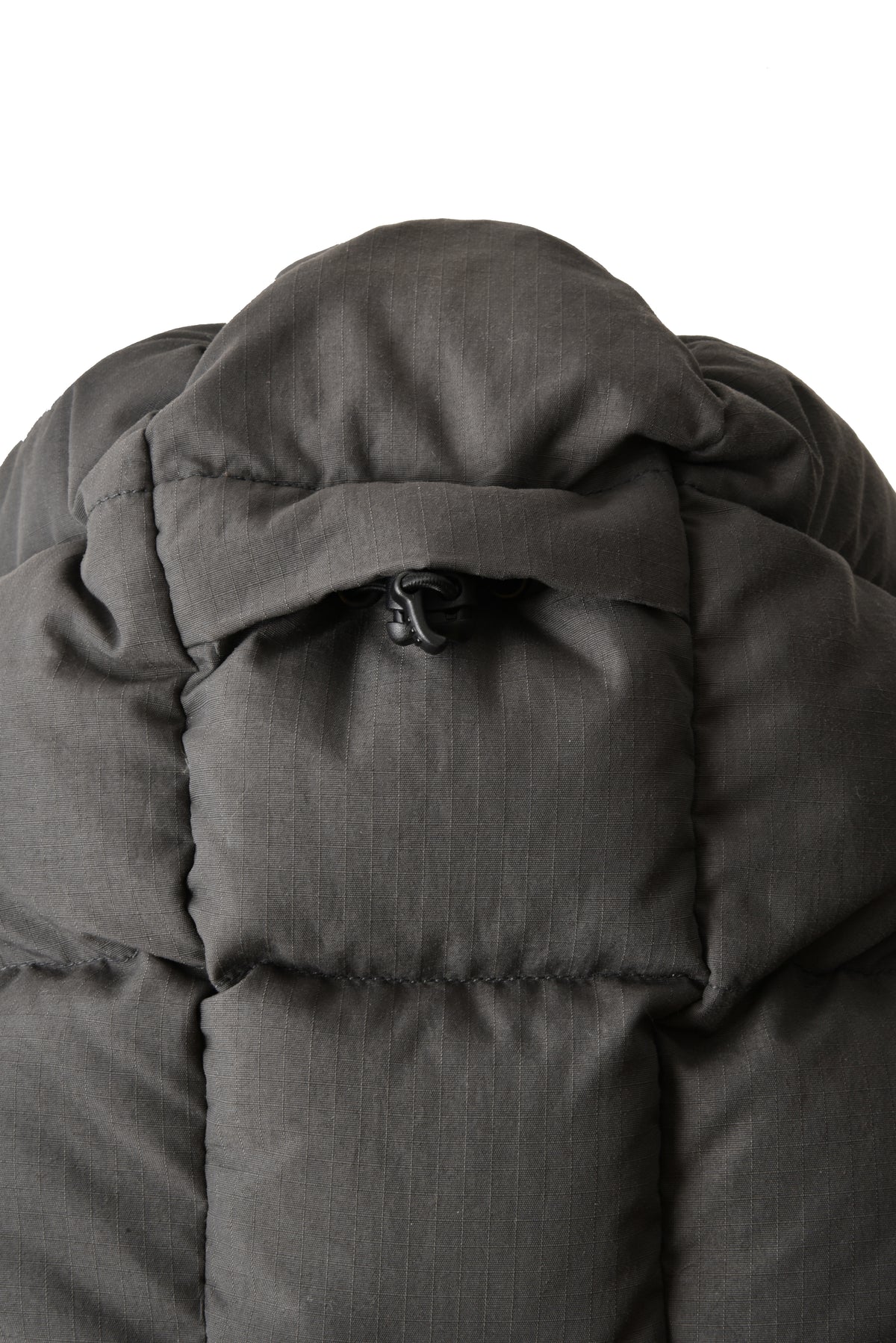 Close-up of a dark gray puffer jacket with a hood on a white background