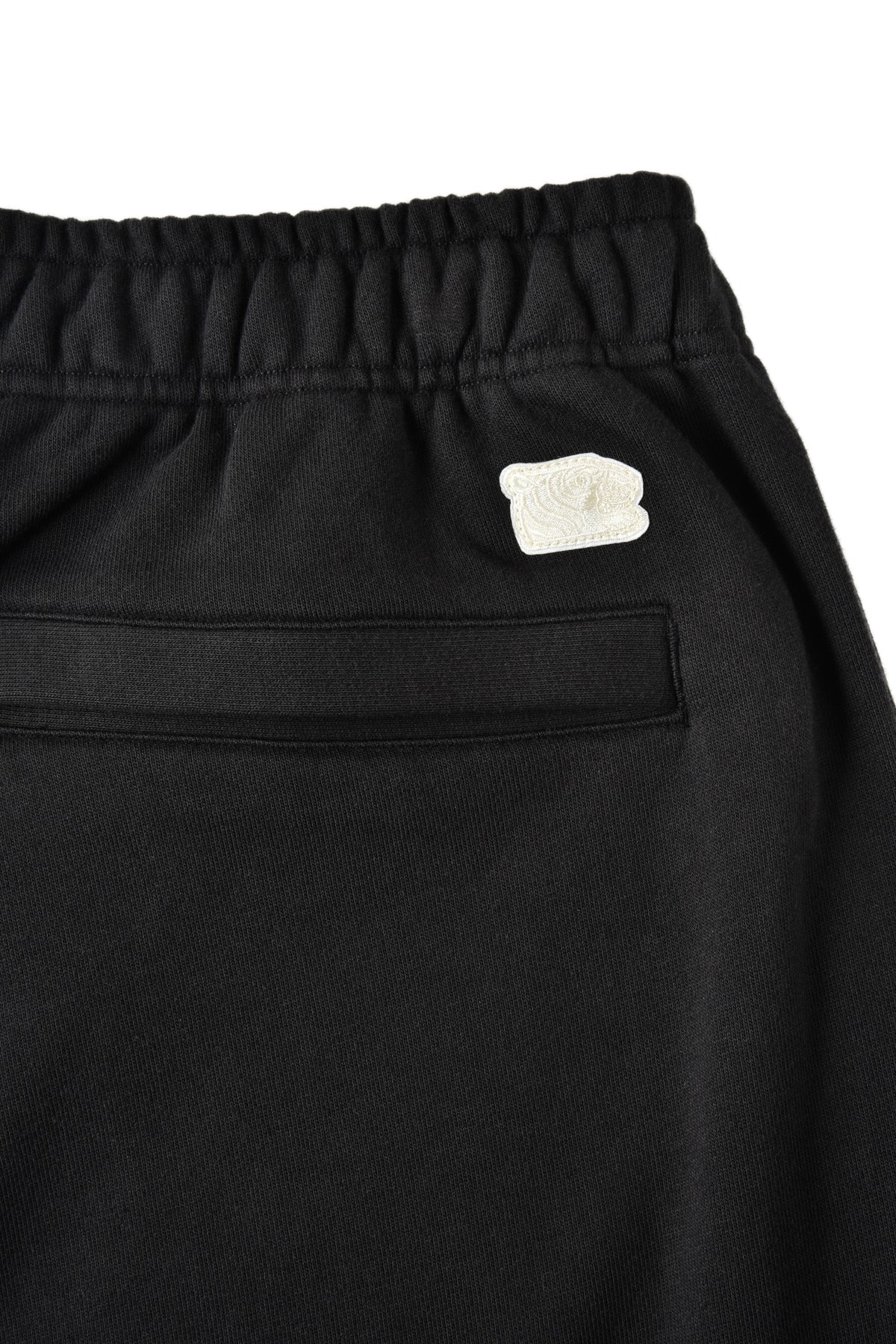 Black pants with a small beige soulgoods  tiger logo on a white background