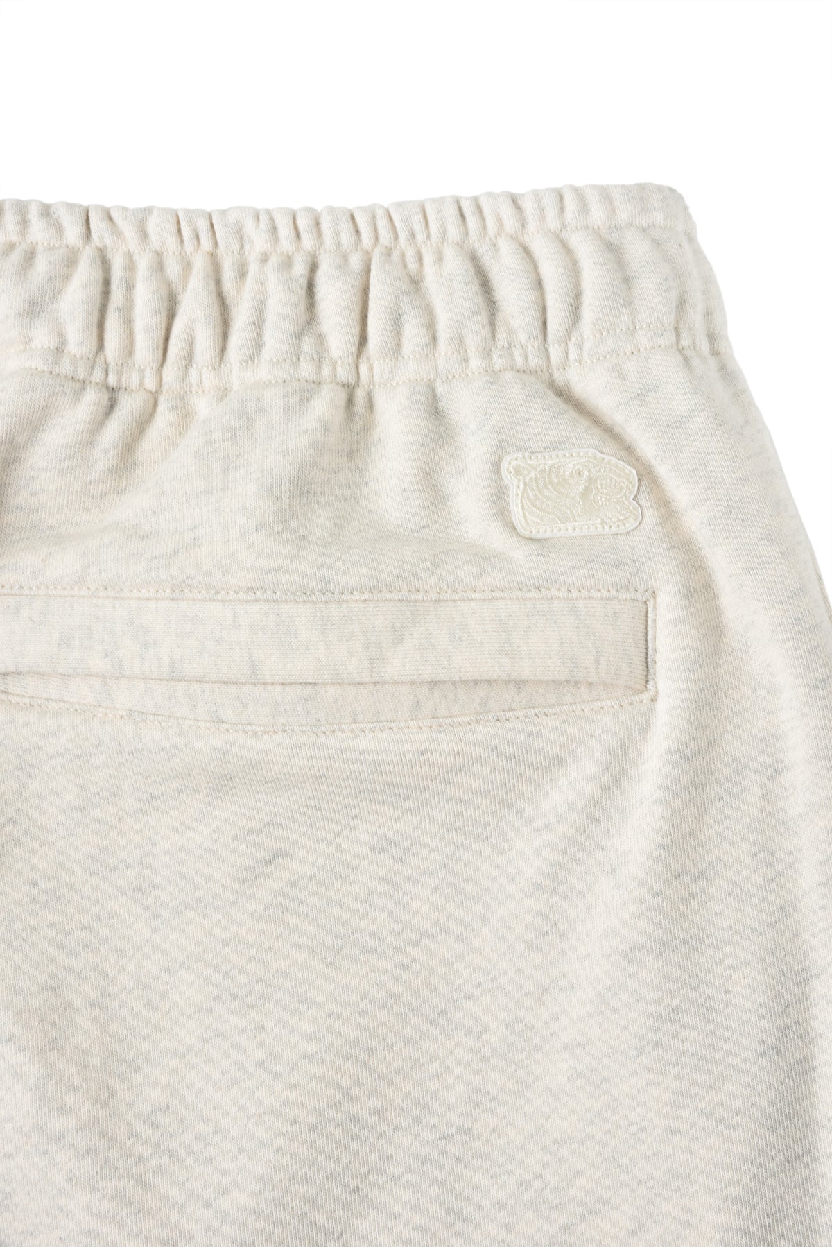 Close-up of beige sweatpants with a soulgoods tiger  label on a white background