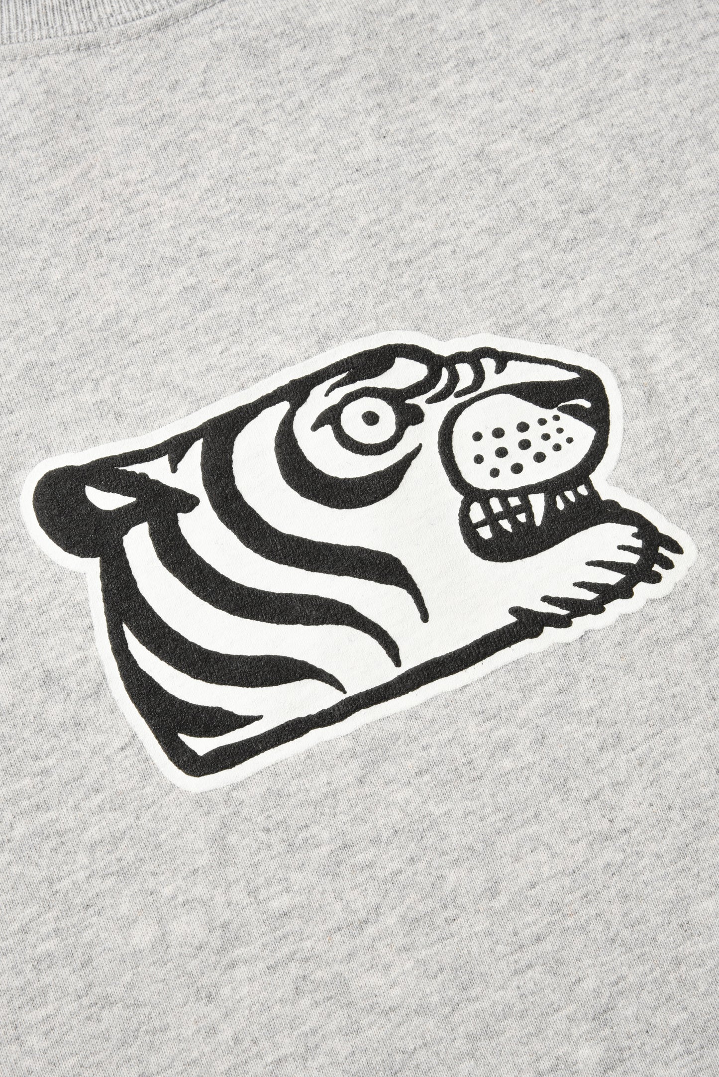 Close-up of a light heather gray sweatshirt featuring a stylized black and white tiger face graphic on the chest.