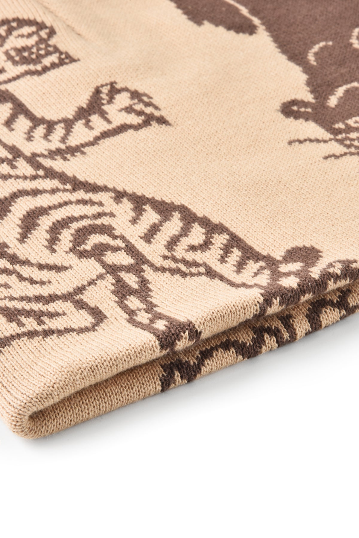 Folded beige fabric with brown abstract patterns on a white background