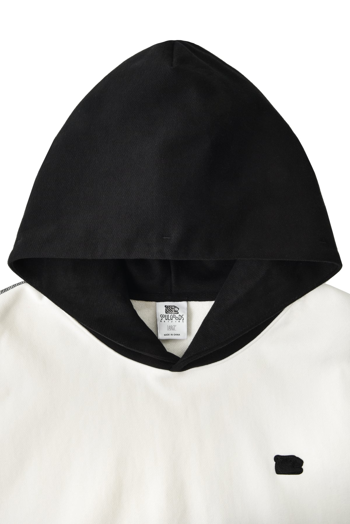 Black hood on a white garment with a visible brand label.
