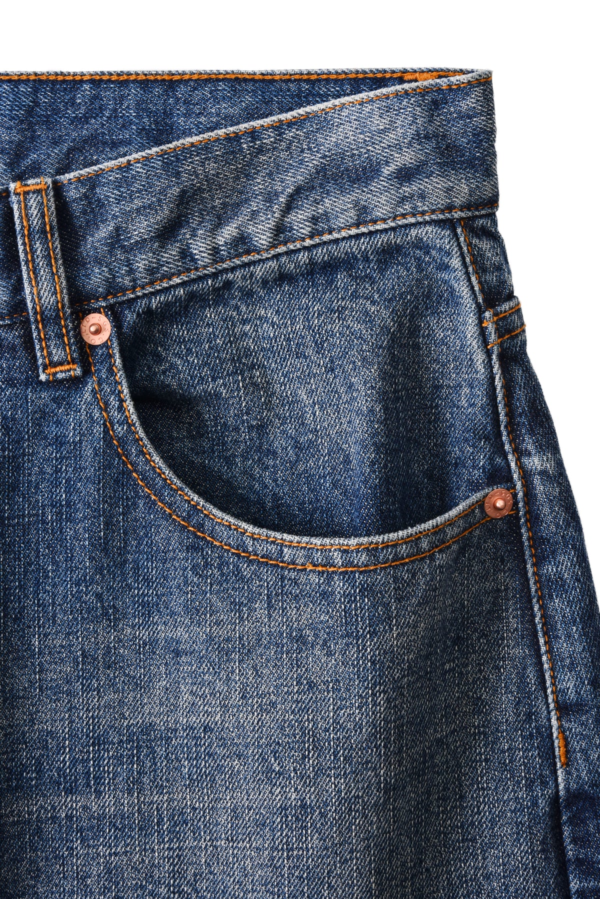 Close-up of blue denim jeans with stitching details on a white background